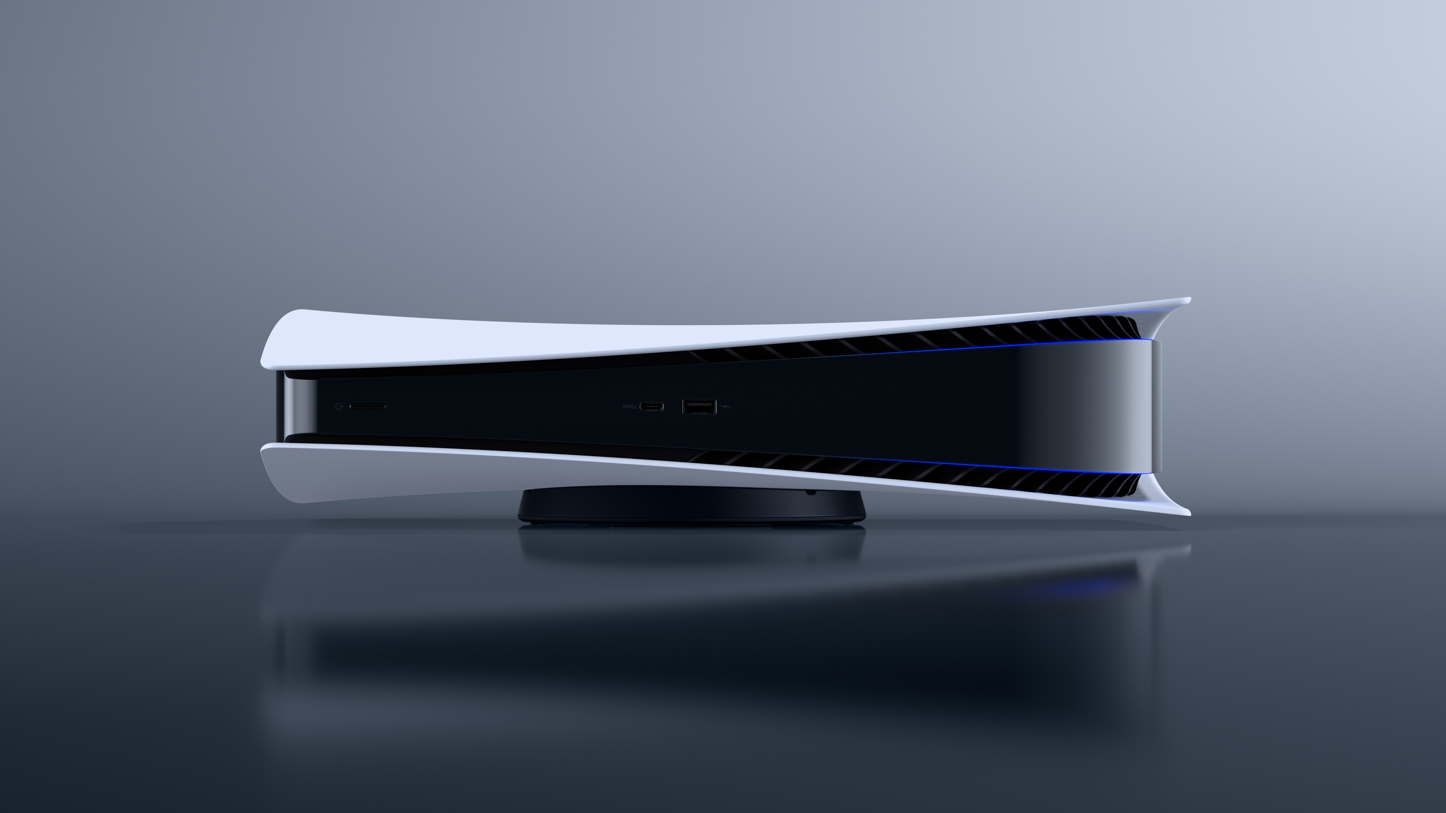 A sleek, white Playstation 5 console rests horizontally on a black stand against a minimalist gray backdrop. The console's glossy black center panel contrasts sharply with its white outer shell, creating a visually striking design