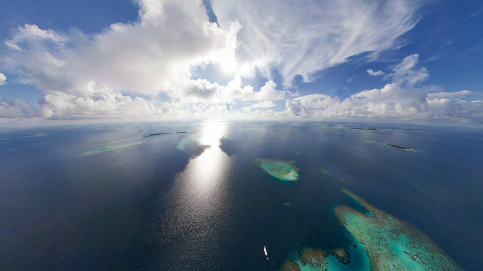 An Island Ocean Sun Clouds Horizon Wallpaper