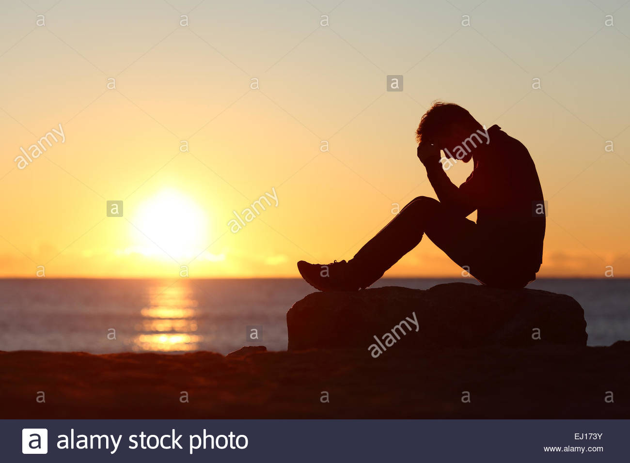 Sad Man Silhouette Worried On The Beach At Sunset With Sun In