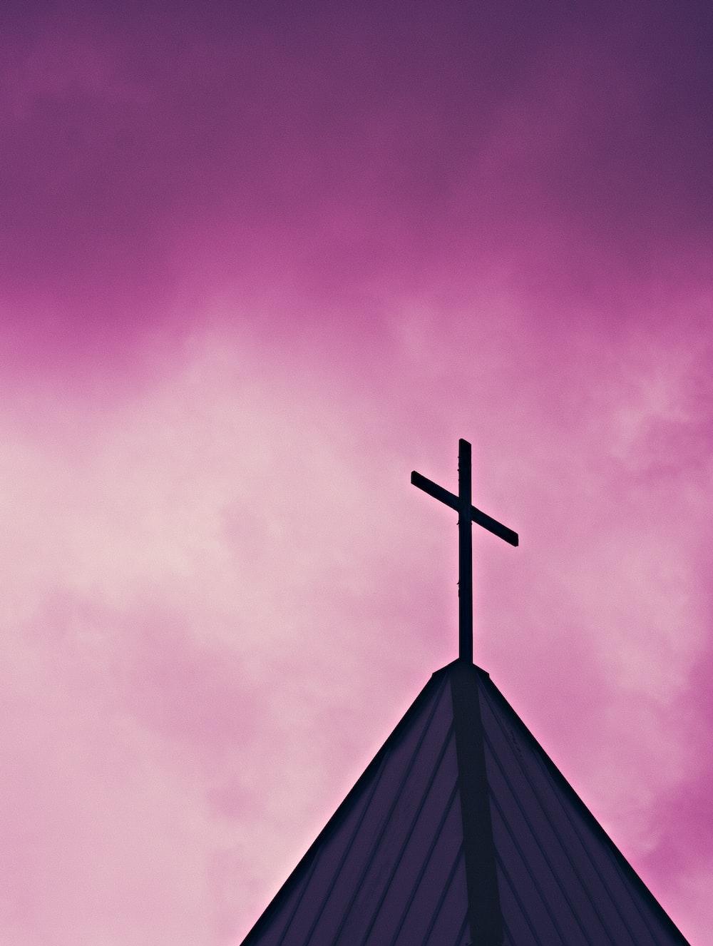 A Cross On Top Of Church Steeple Against Purple Sky Photo
