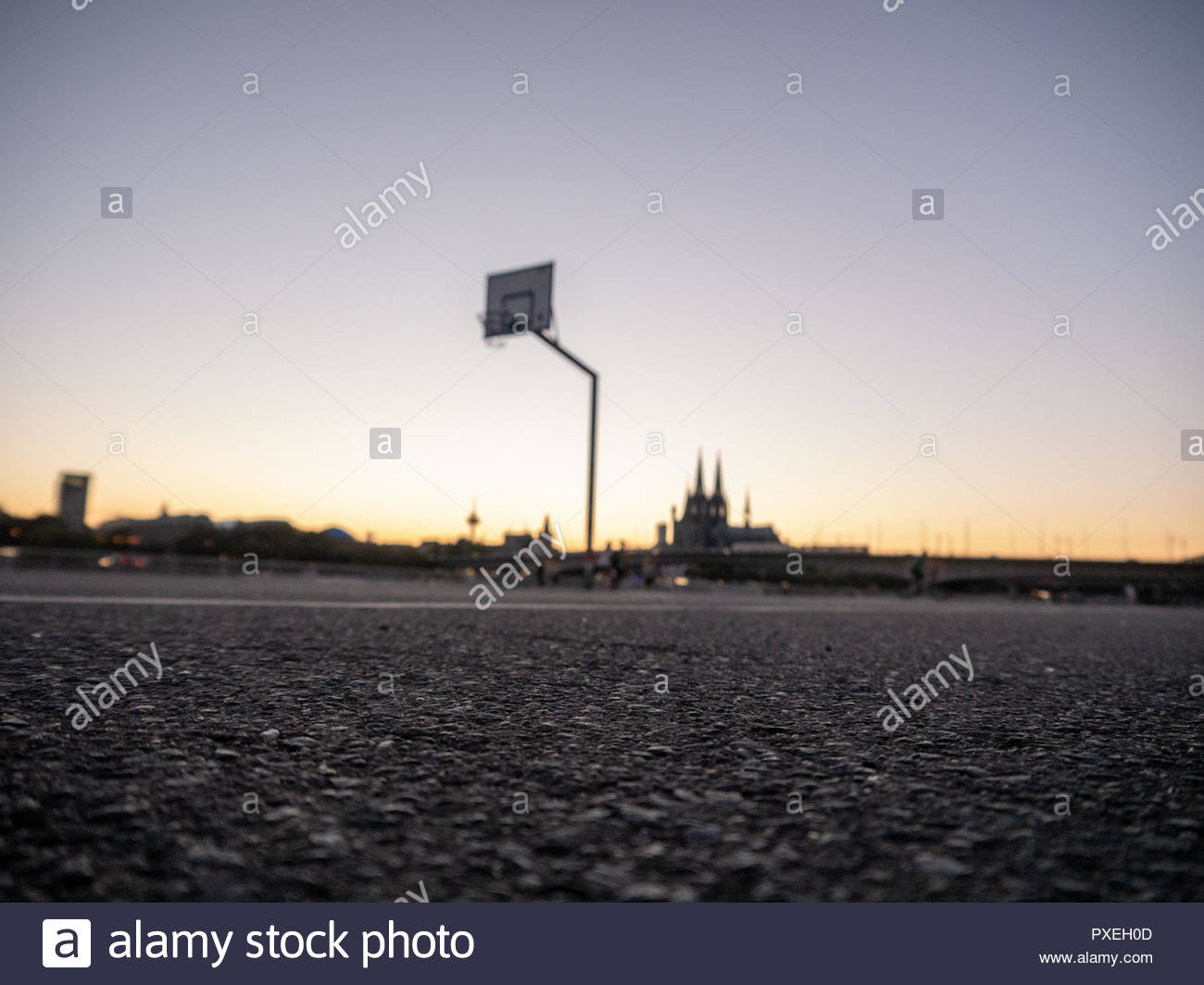 Urban Basketball Hoop At Sunset With Skyline Of Cologne Germany