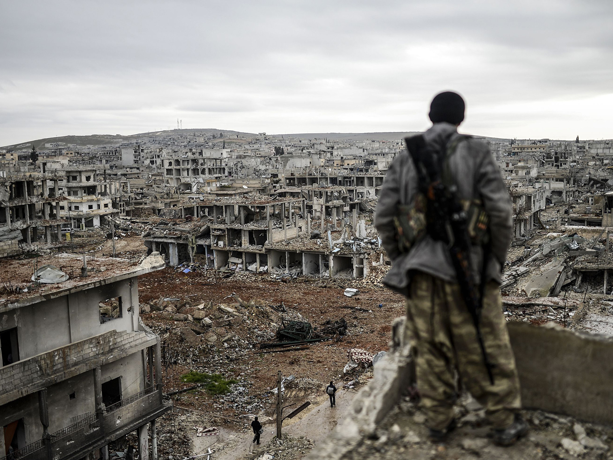 A lone figure stands amidst the rubble and destruction of a Syrian city, a stark reminder of the devastating impact of war