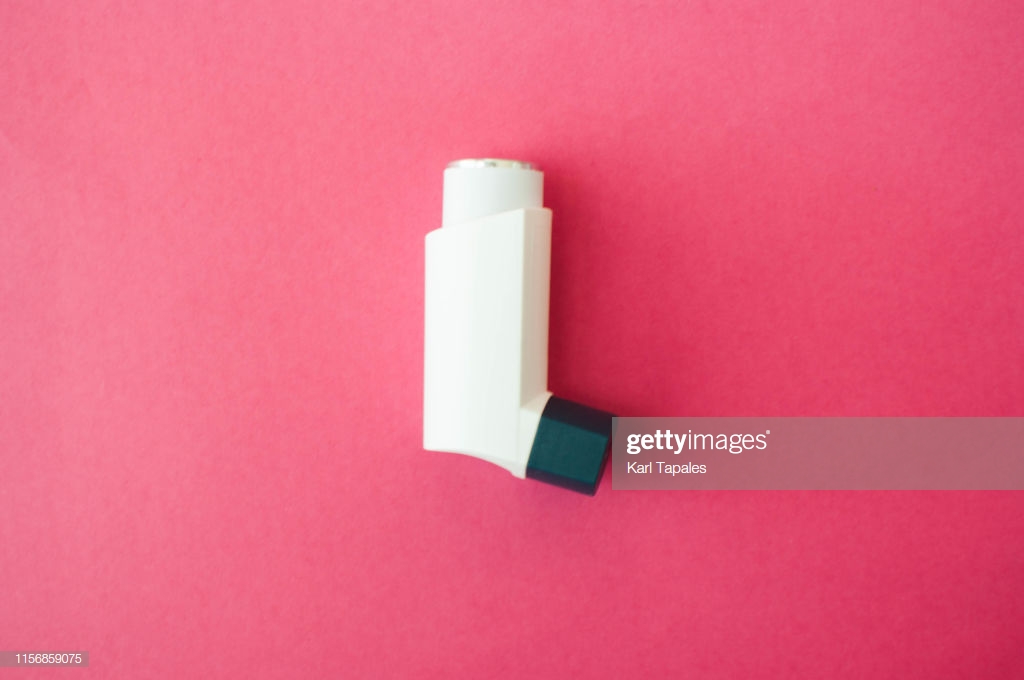 A Flatlay Of Asthma Metereddose Inhaler On Pink Background Stock