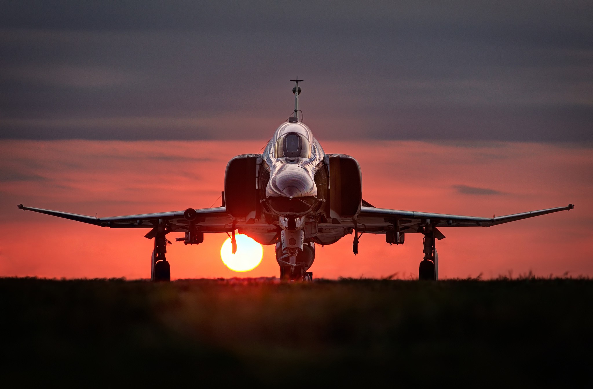 Silhouette of a Fighter Jet against a Dramatic Sunset