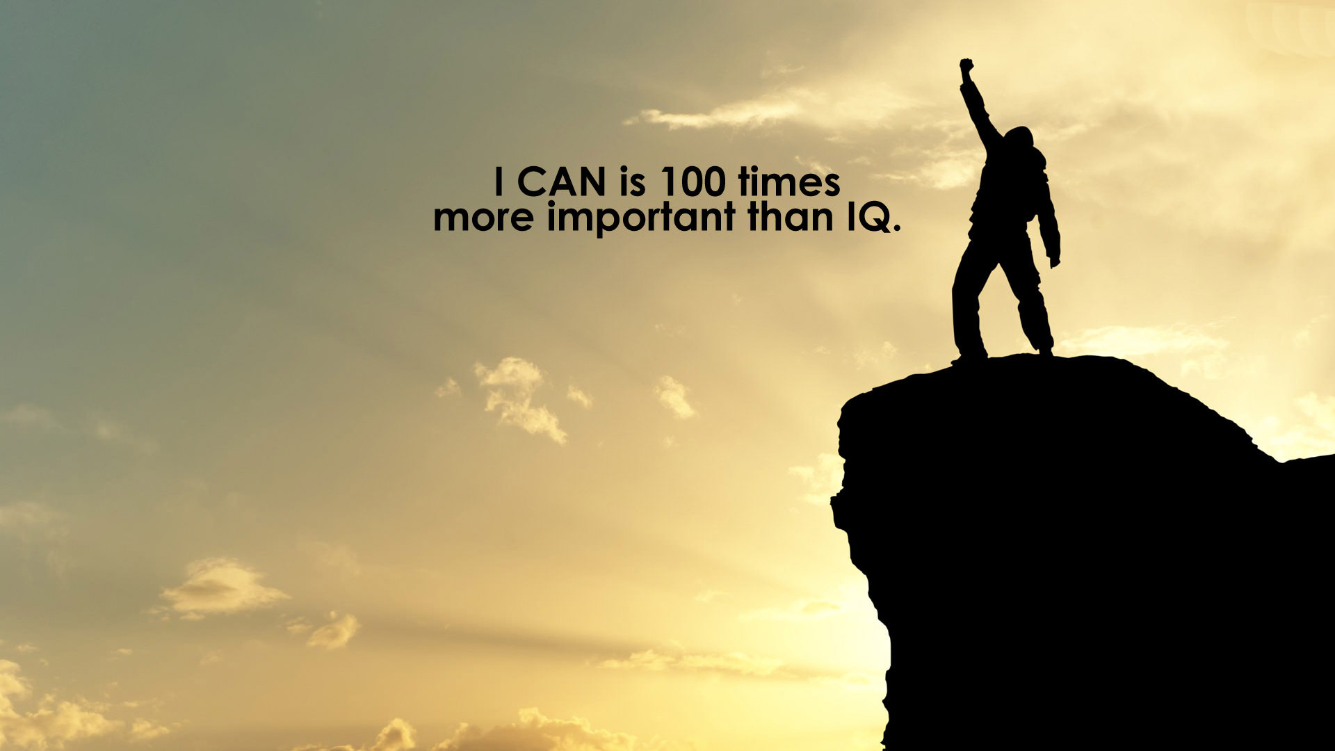 Silhouette of a person standing on a cliff with a raised fist against a sunset sky with the quote 'I CAN is 100 times more important than IQ.'