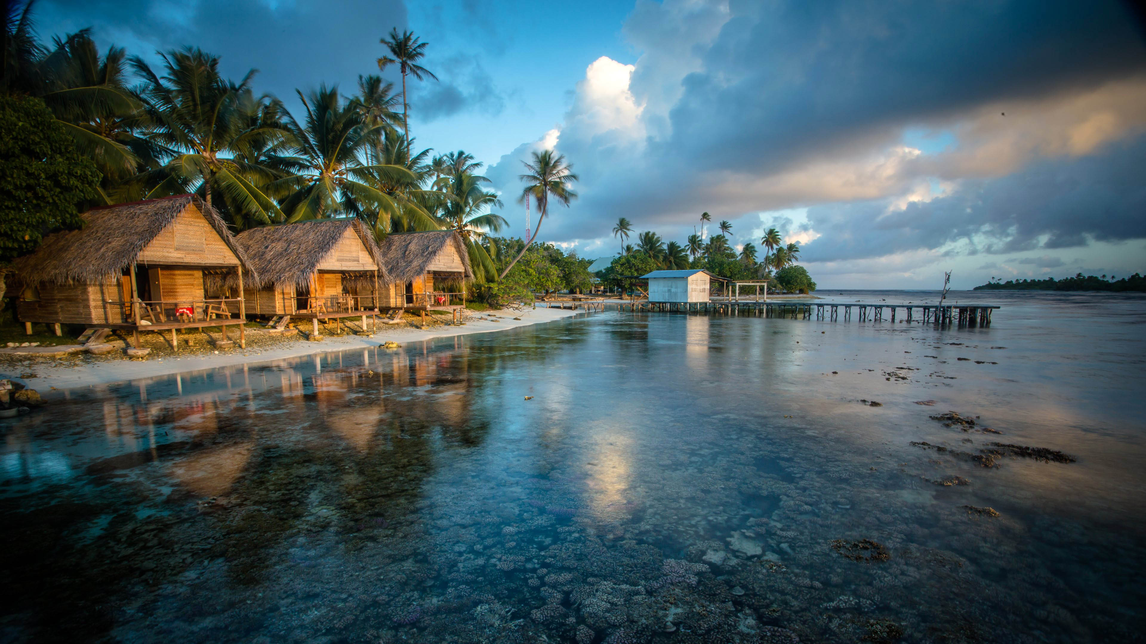 Tropical bungalows on a beach at sunset
