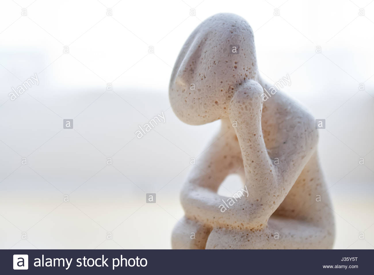 Small Statue Of Stone Man Thinking Pause For Thought Light Stock