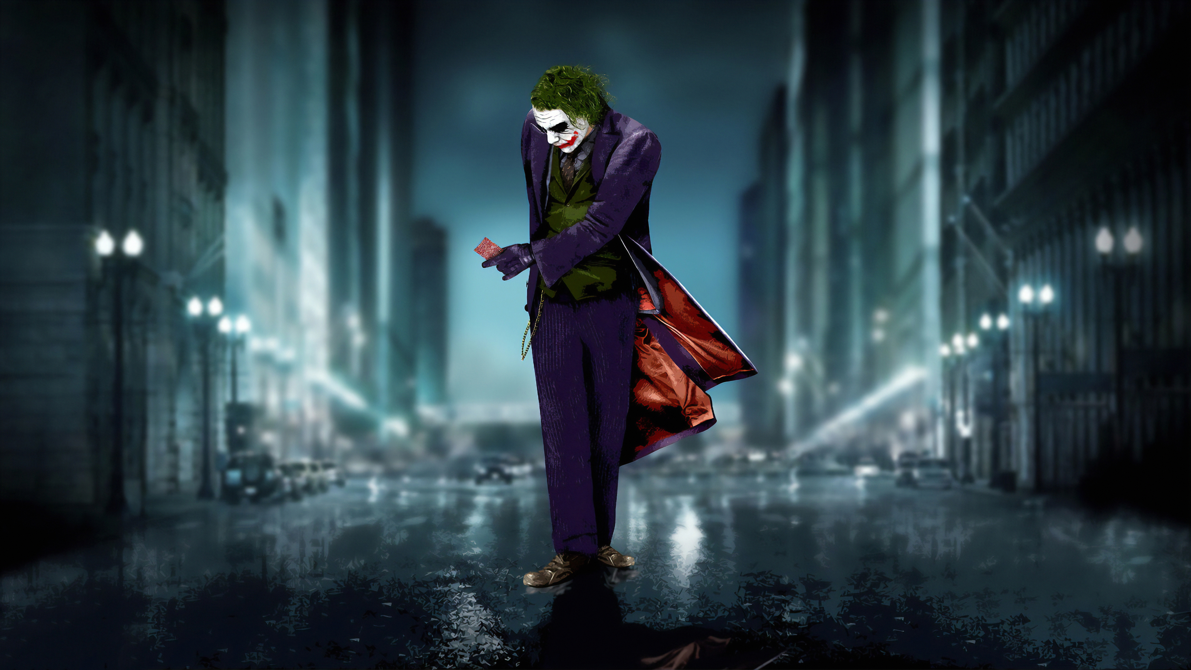 The Joker stands in a dark, rainy city street, holding a playing card. This image evokes a sense of mystery and chaos, characteristic of the iconic villain