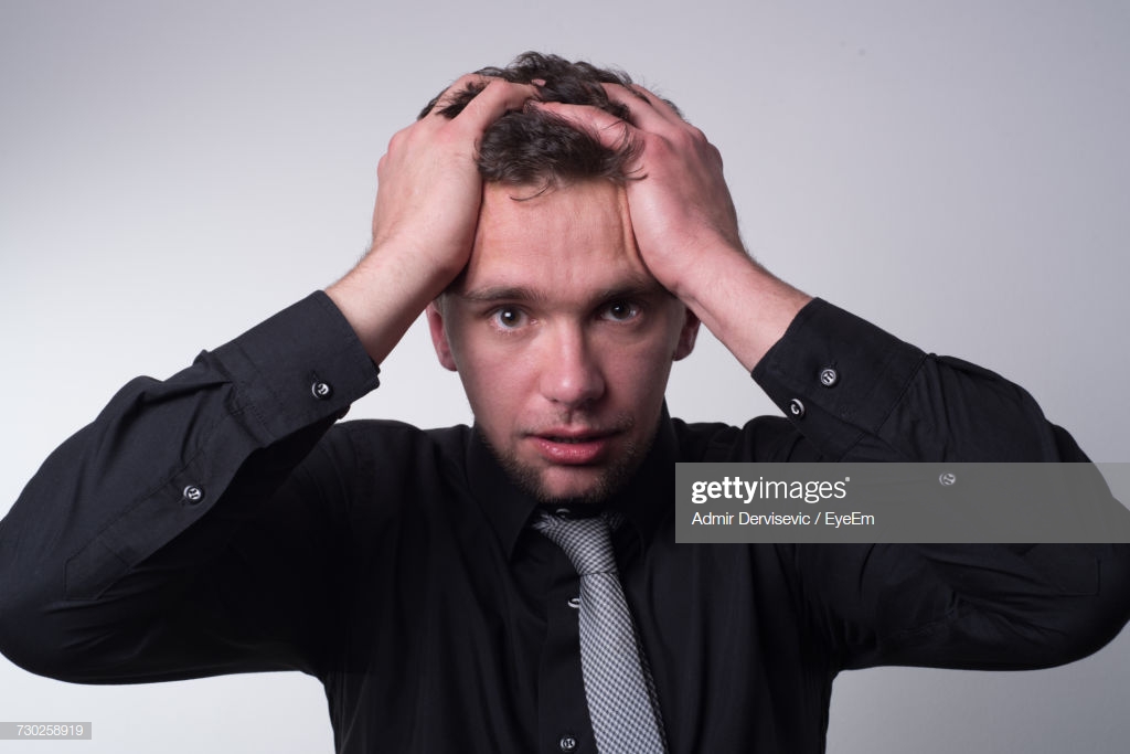 Portrait Of Worried Businessman Against Gray Background Stock
