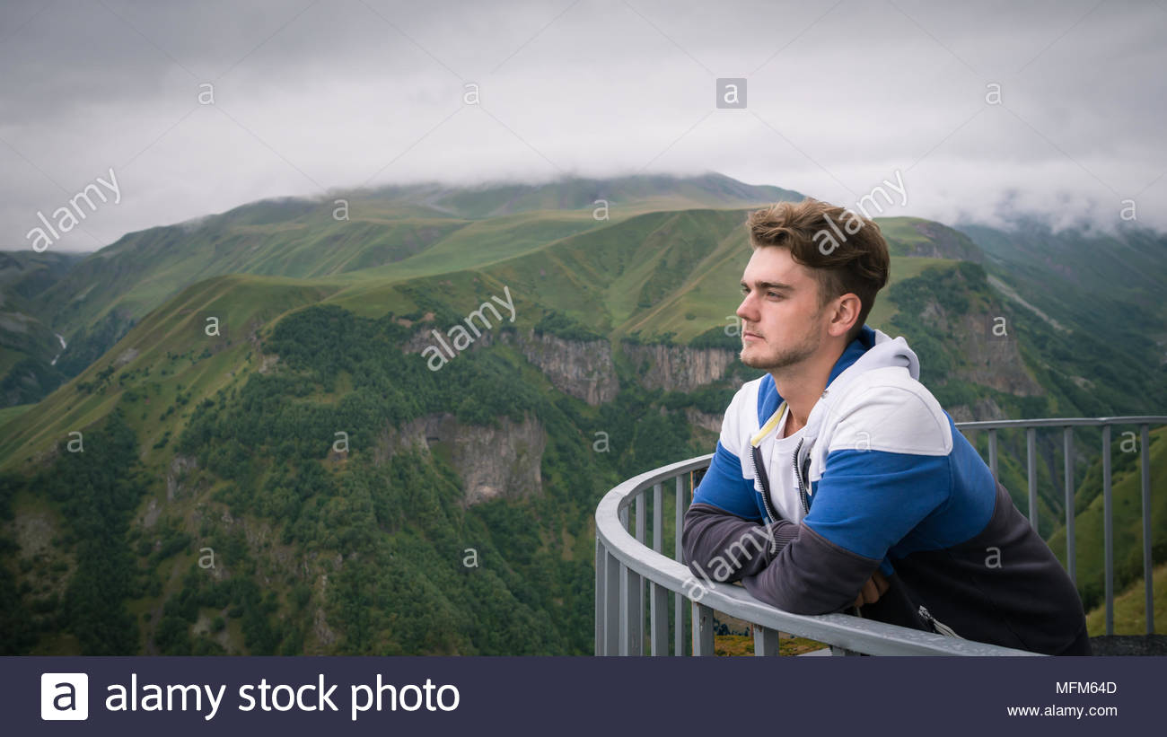 Young Man Stands At Observation Deck On Background Of Beautiful