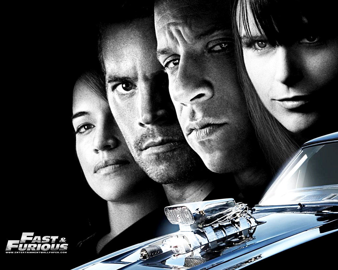 Black and white promotional image for The Fast and the Furious featuring Vin Diesel, Paul Walker, Michelle Rodriguez, and Jordana Brewster with a classic muscle car