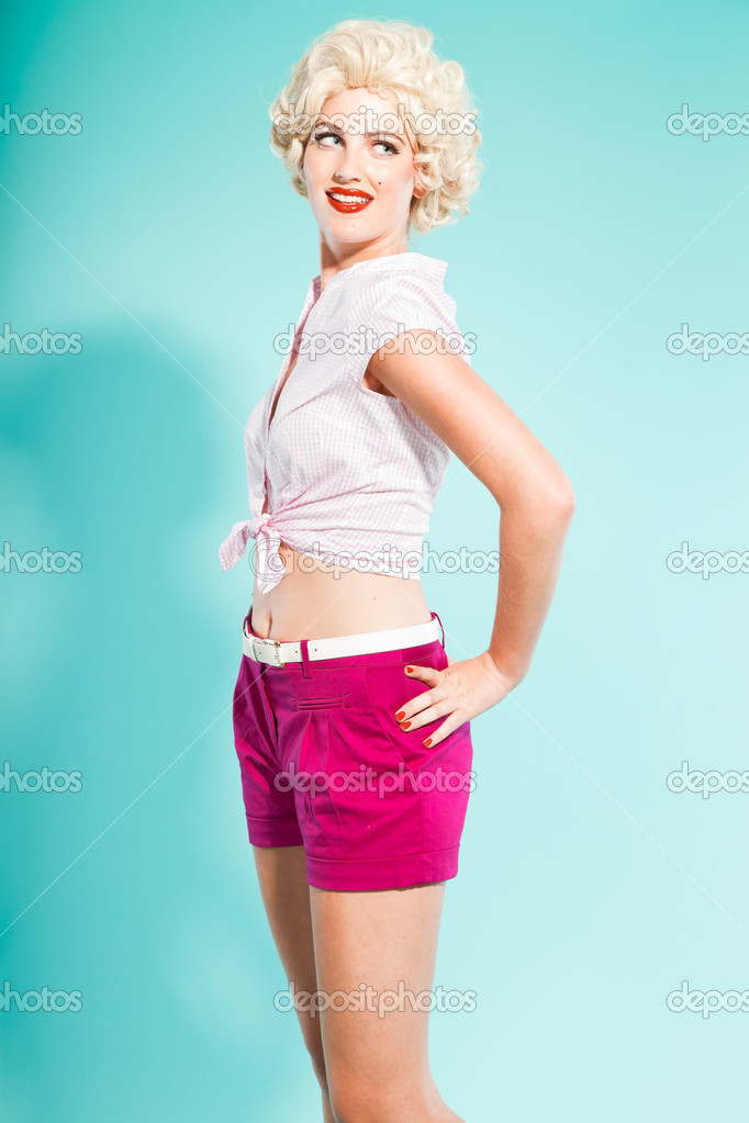 Sexy Blonde Pin Up Girl Wearing Pink Shirt And Hot Pants Holding