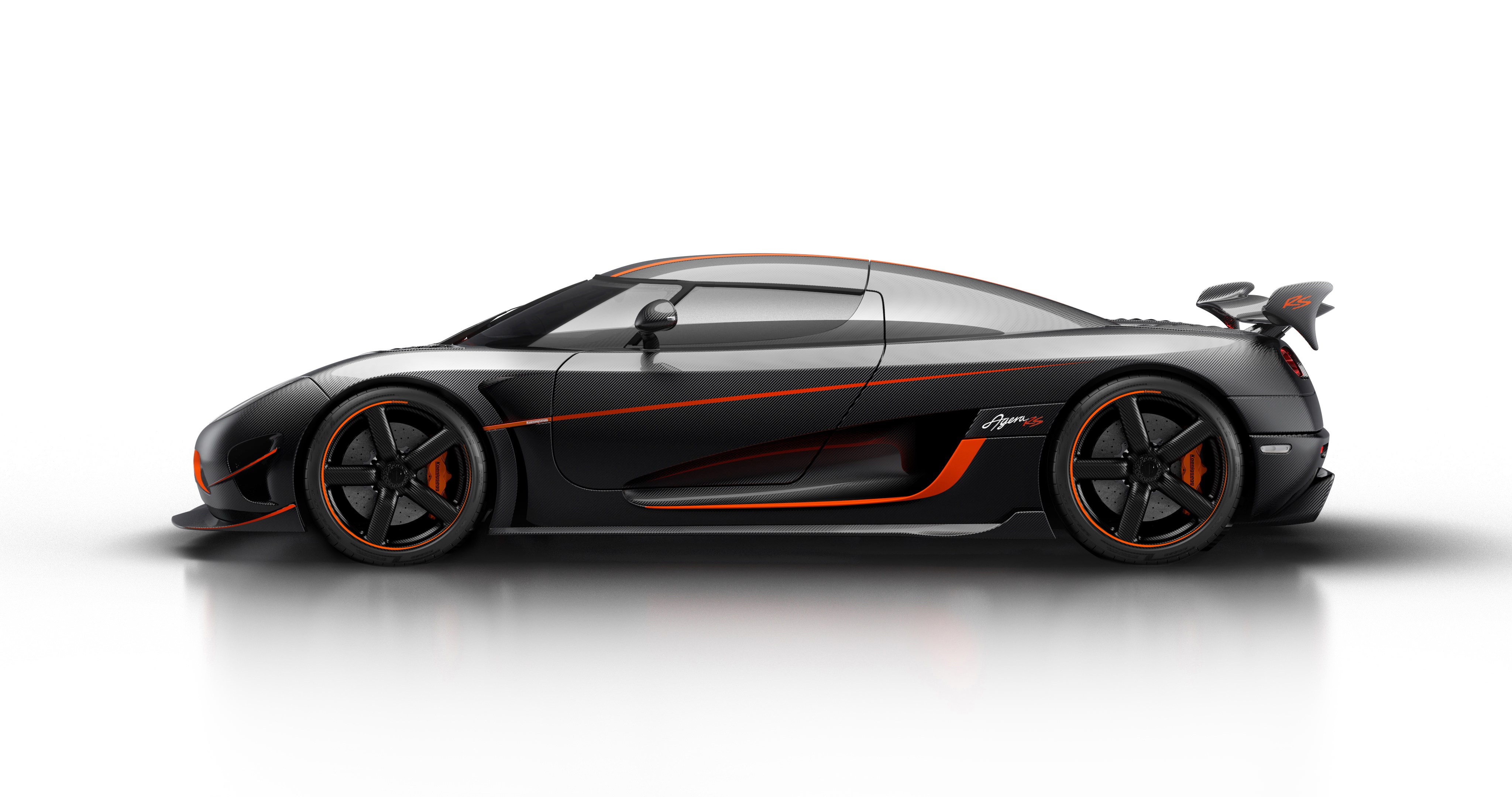 Side view of a sleek black Koenigsegg Agera RS with orange accents, highlighting its aerodynamic design and carbon fiber body