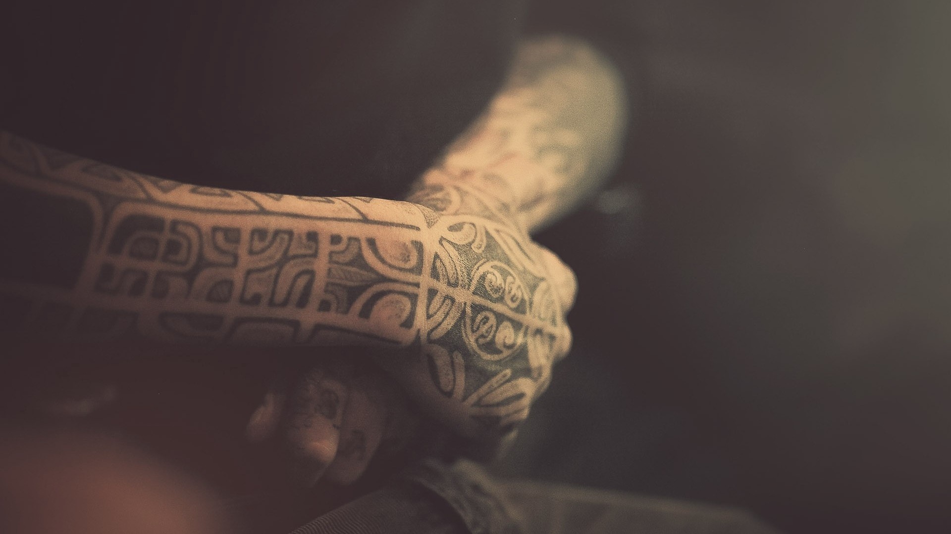 Close-up of hands with intricate tribal tattoos