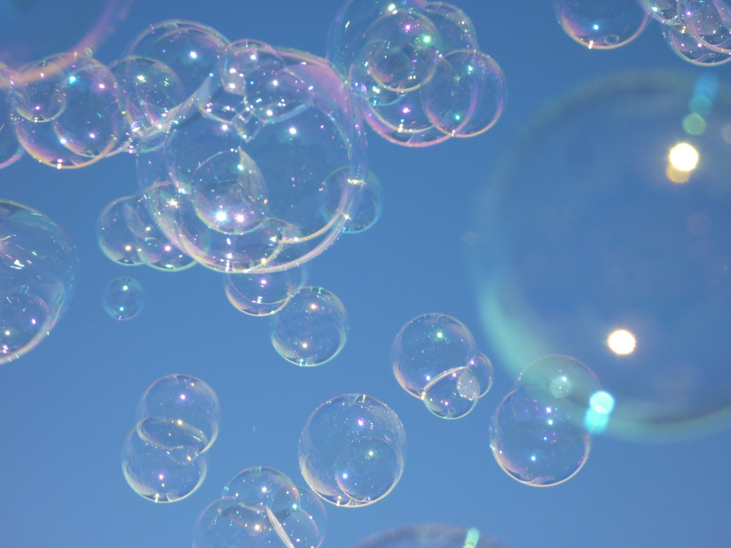 Floating soap bubbles against a blue sky