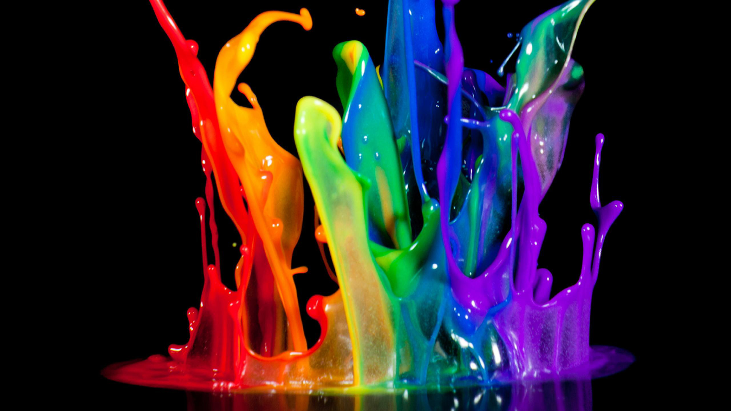 A vibrant explosion of colorful paint splattering against a black background, creating an energetic and abstract visual