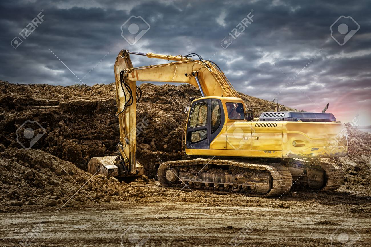 Excavator Machinery At Construction Site Cloudy Sky In Background