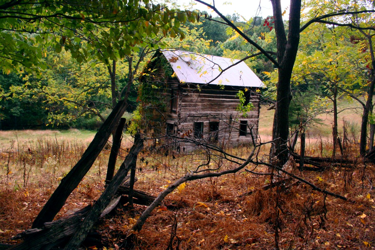 An Old Abandoned Farm House Scene With Autumn Leaves Changing Around