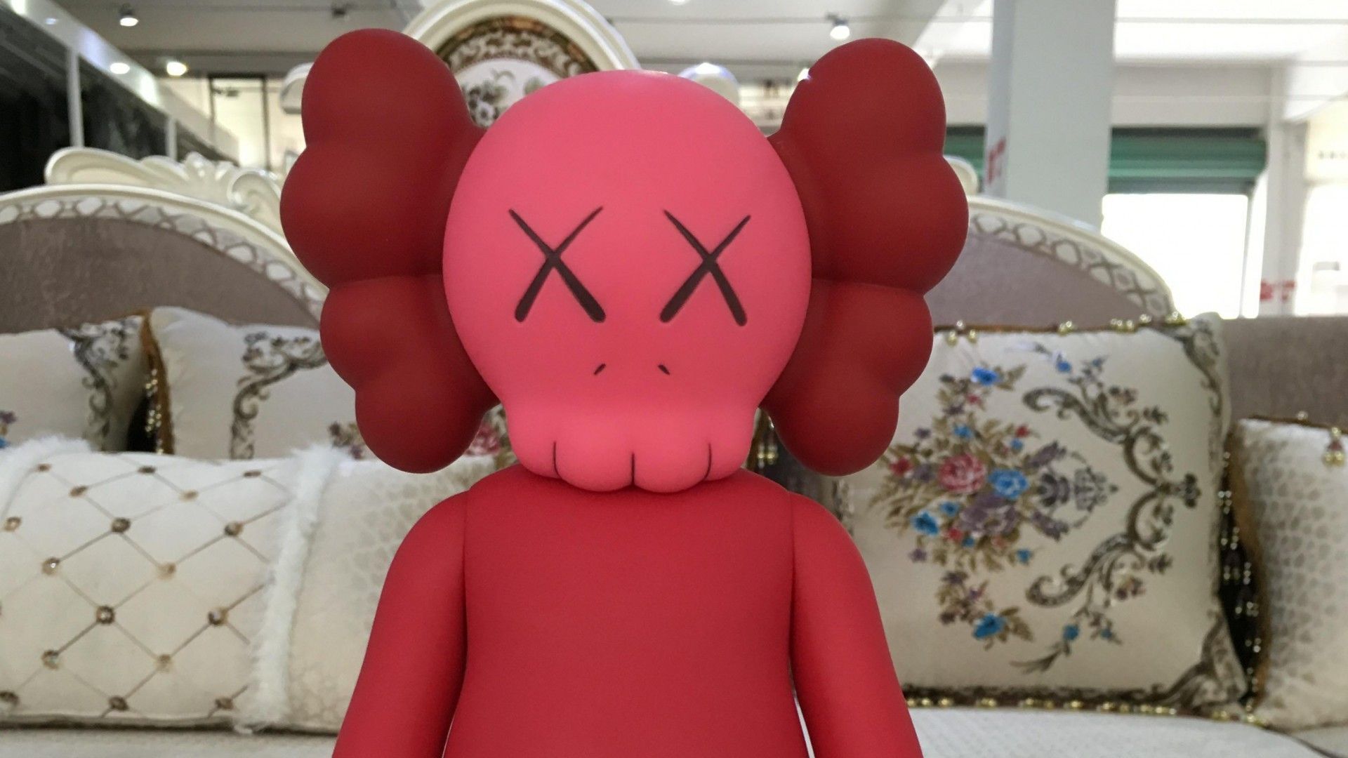 Red Kaws Companion Figure on a Sofa