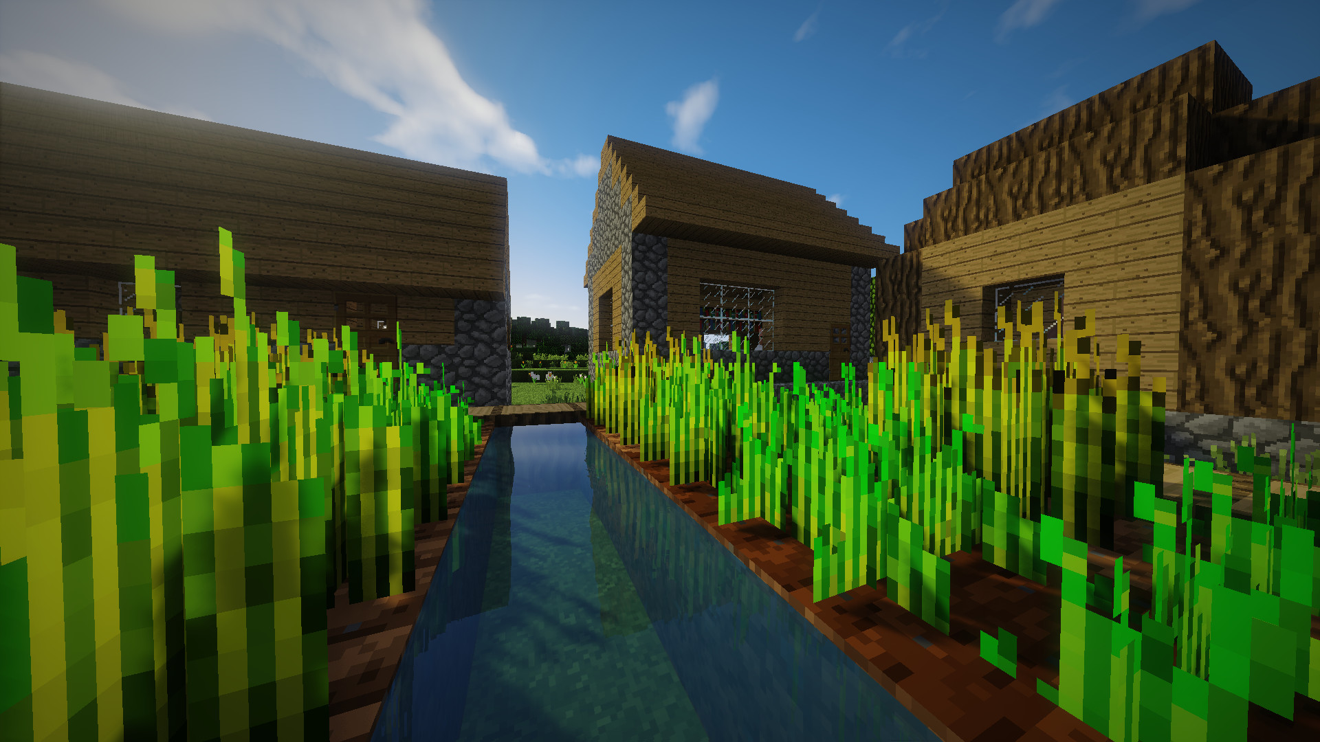 A picturesque view of a Minecraft village with a canal running through crops and alongside wooden houses, showcasing the game's charming pixelated graphics in HD
