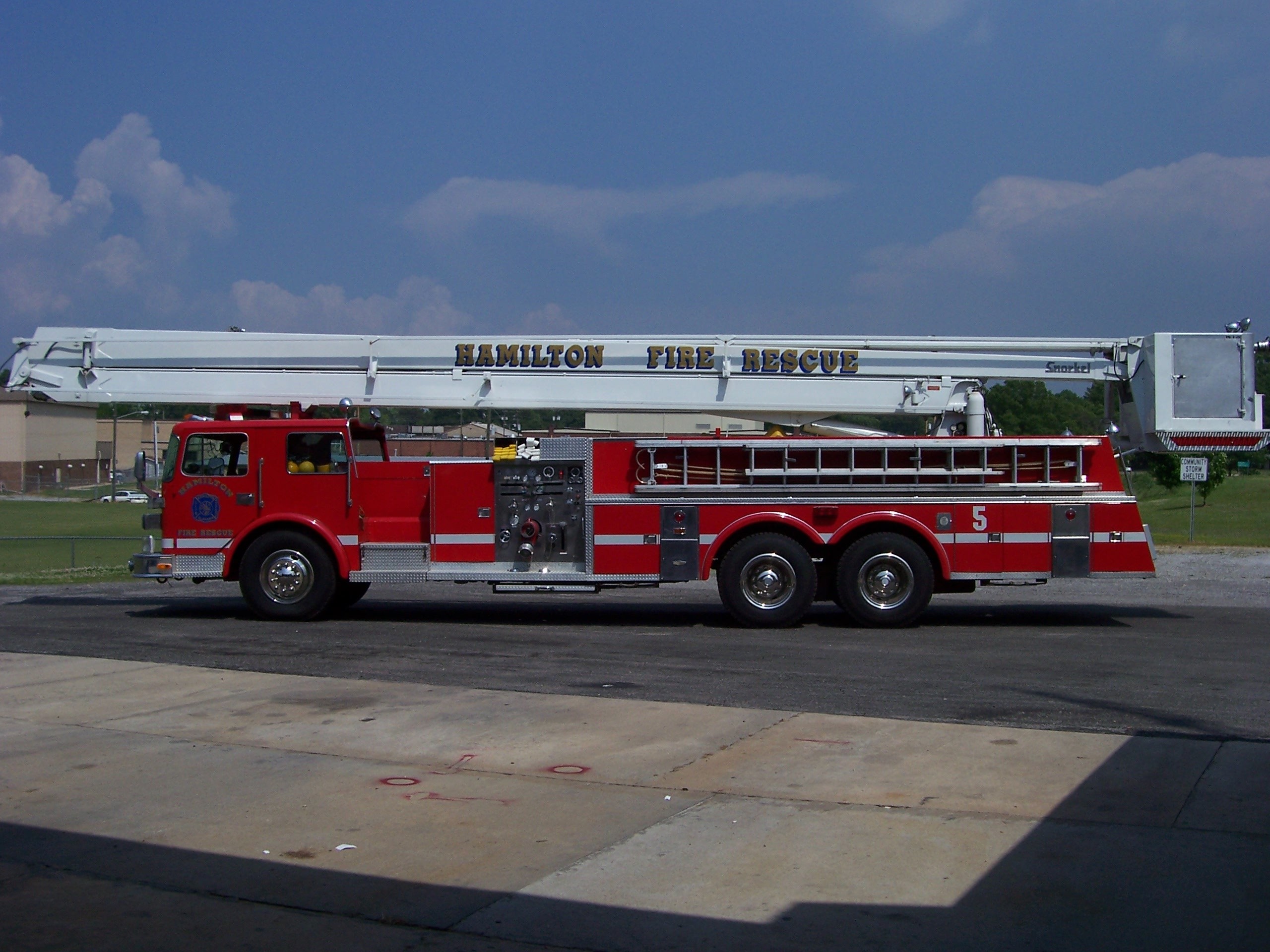 A Hamilton Fire Rescue truck with a raised platform, parked on a paved surface