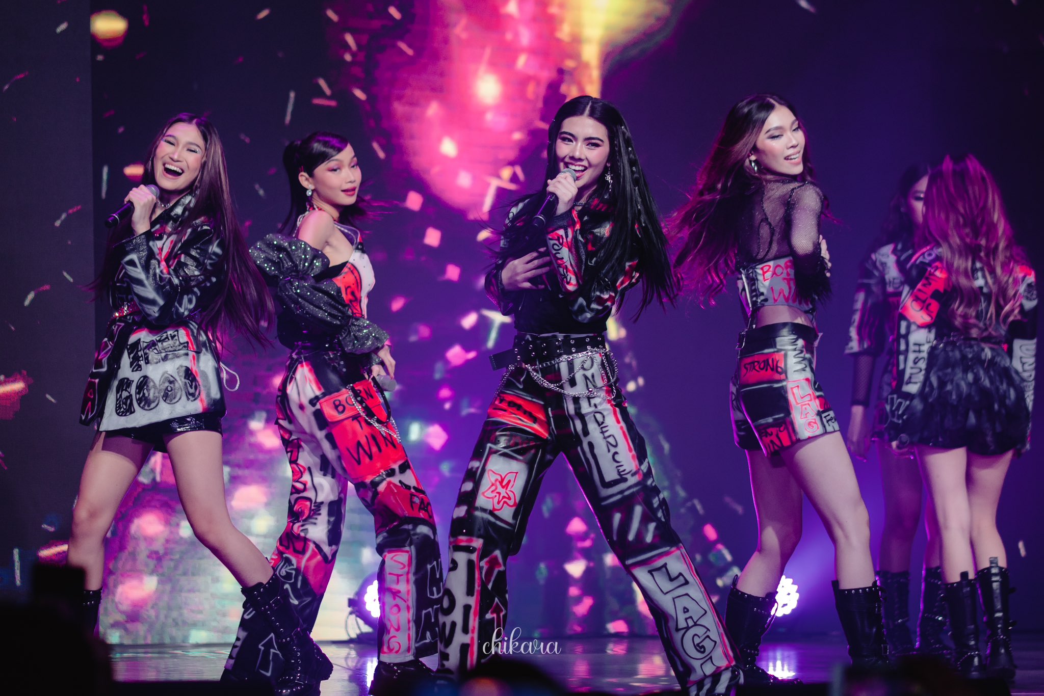 BINI girl group performing live on stage in stylish graffiti-inspired outfits