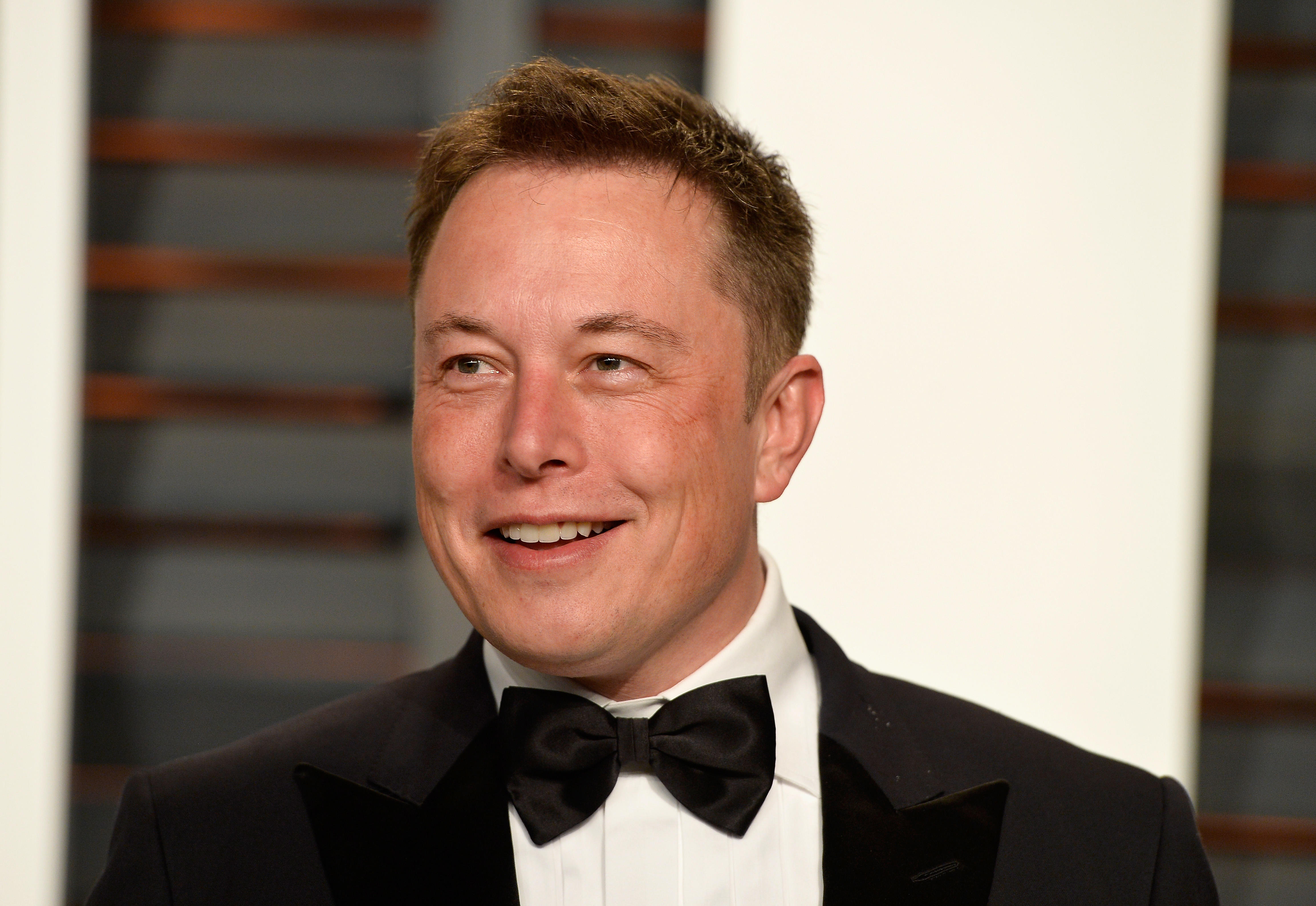 Elon Musk at a formal event, wearing a tuxedo and bow tie, smiling