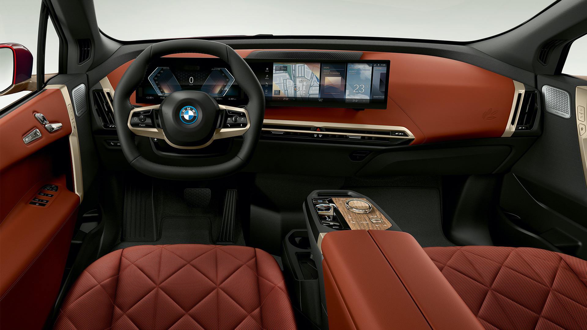 Interior view of a BMW iX showcasing its modern dashboard, steering wheel, and luxurious leather seats