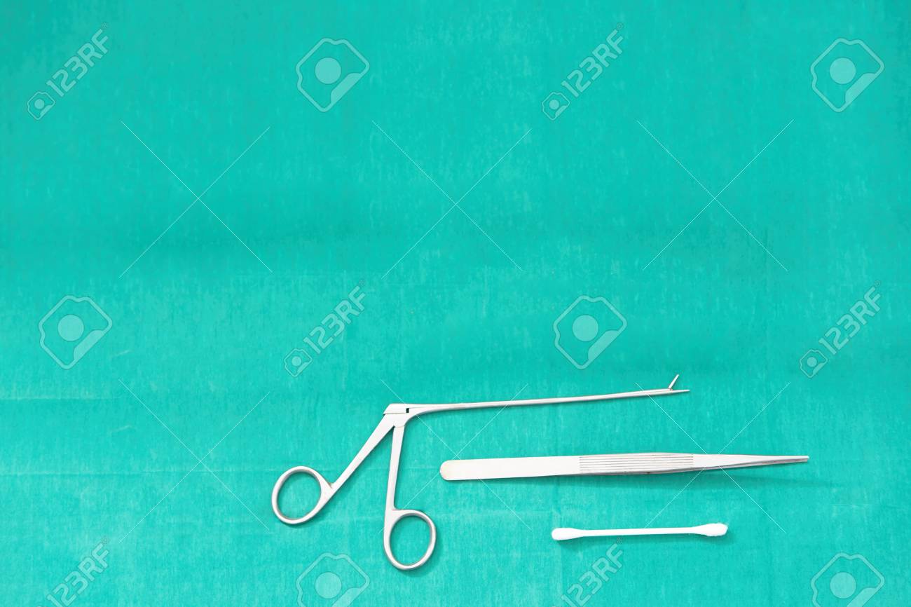 Alligator Forceps And Cotton Bud On Green Surgery Background Stock