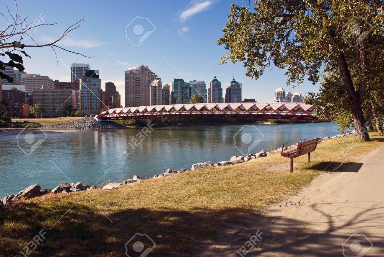 A Pedestrian Bridge Accross Bow River In Calgary With Skyscrapers