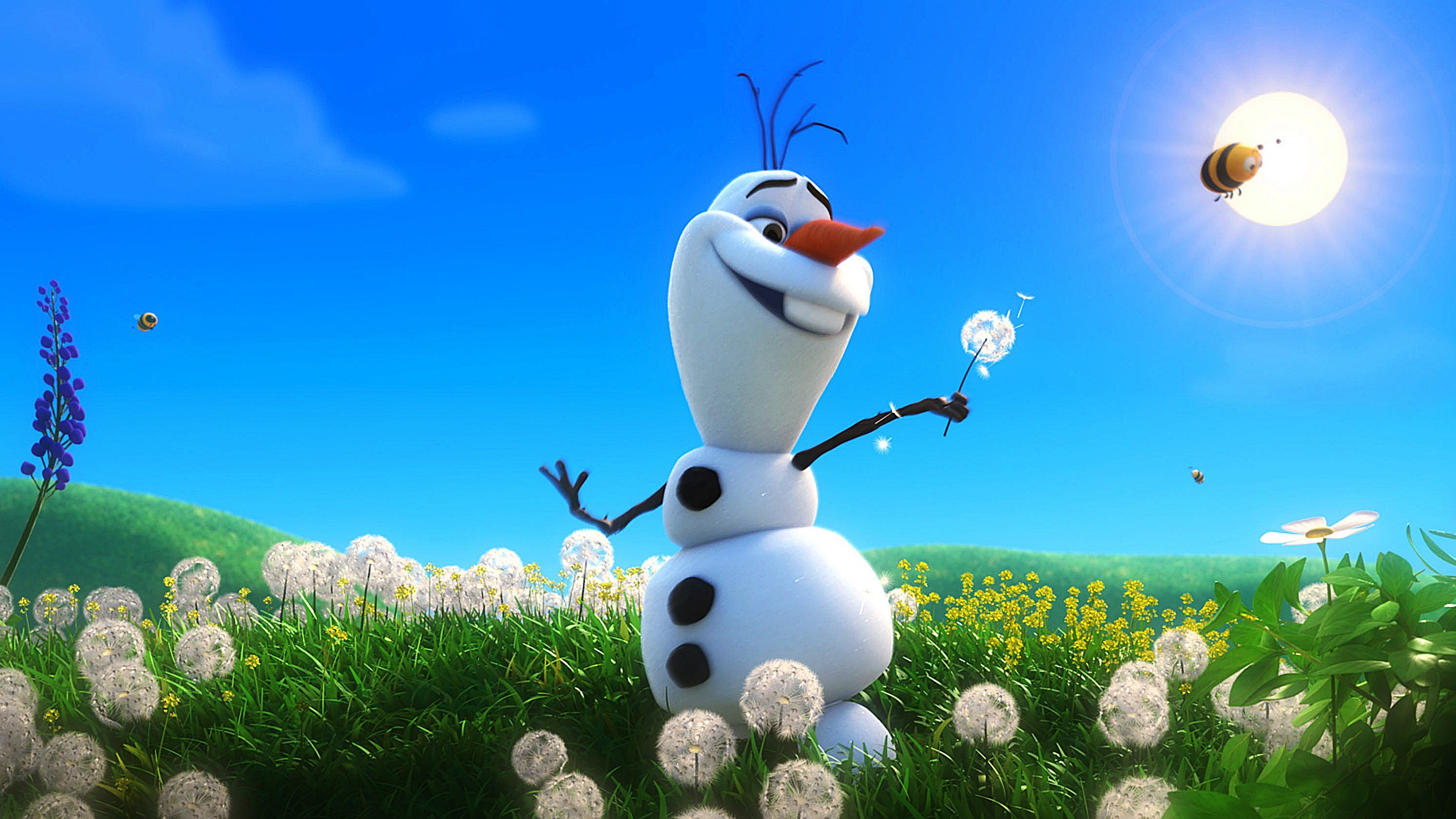 A cheerful cartoon snowman stands in a field of dandelions, holding one in his hand, under a bright blue sky with bees and sunshine