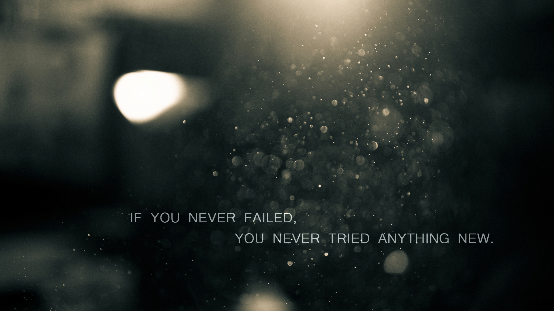 A blurry image of dust particles with a motivational quote about embracing failure as a part of trying new things