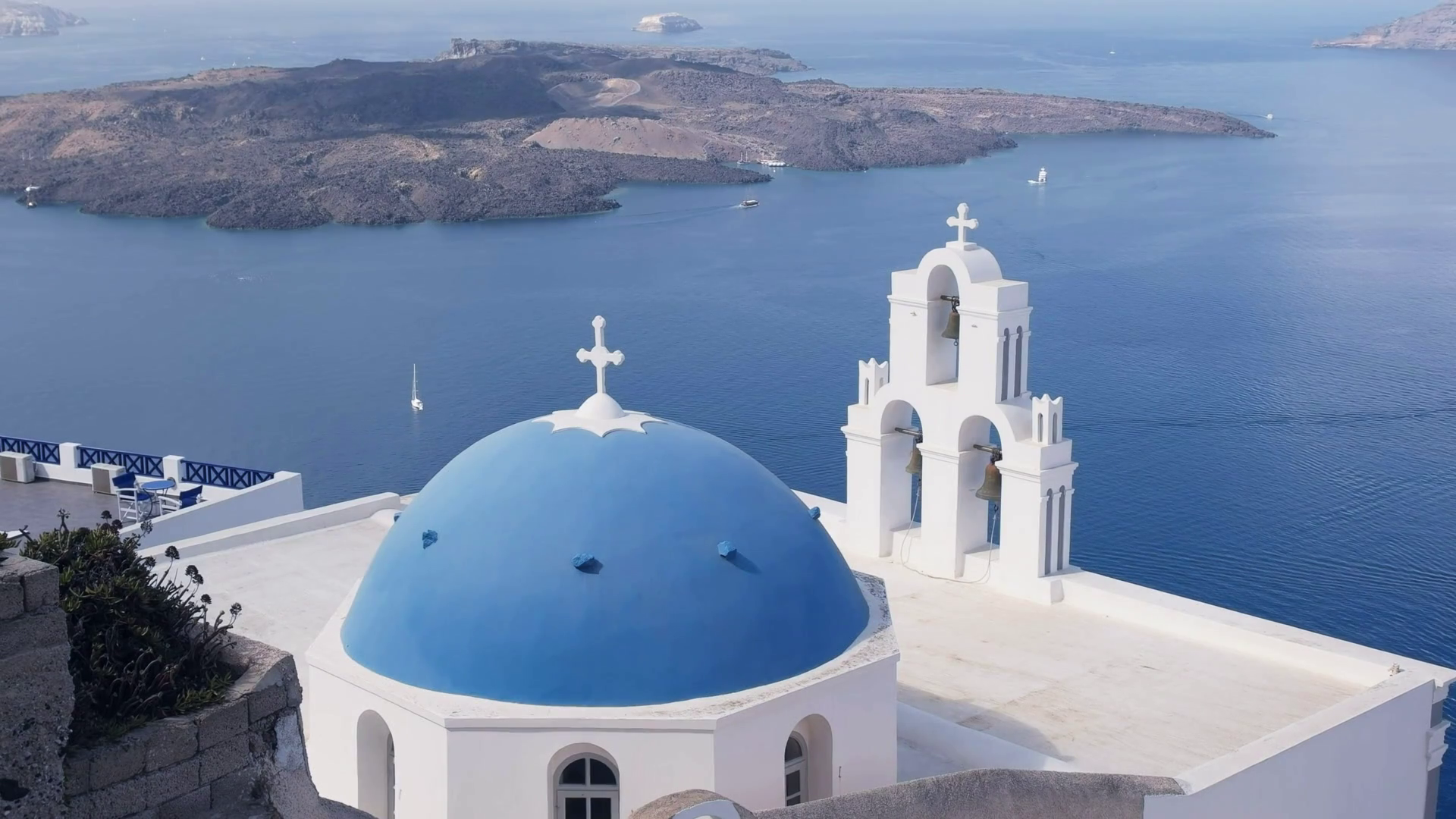 Wide Shot Of A Blue Church Dome And Three Bells In Fira On The