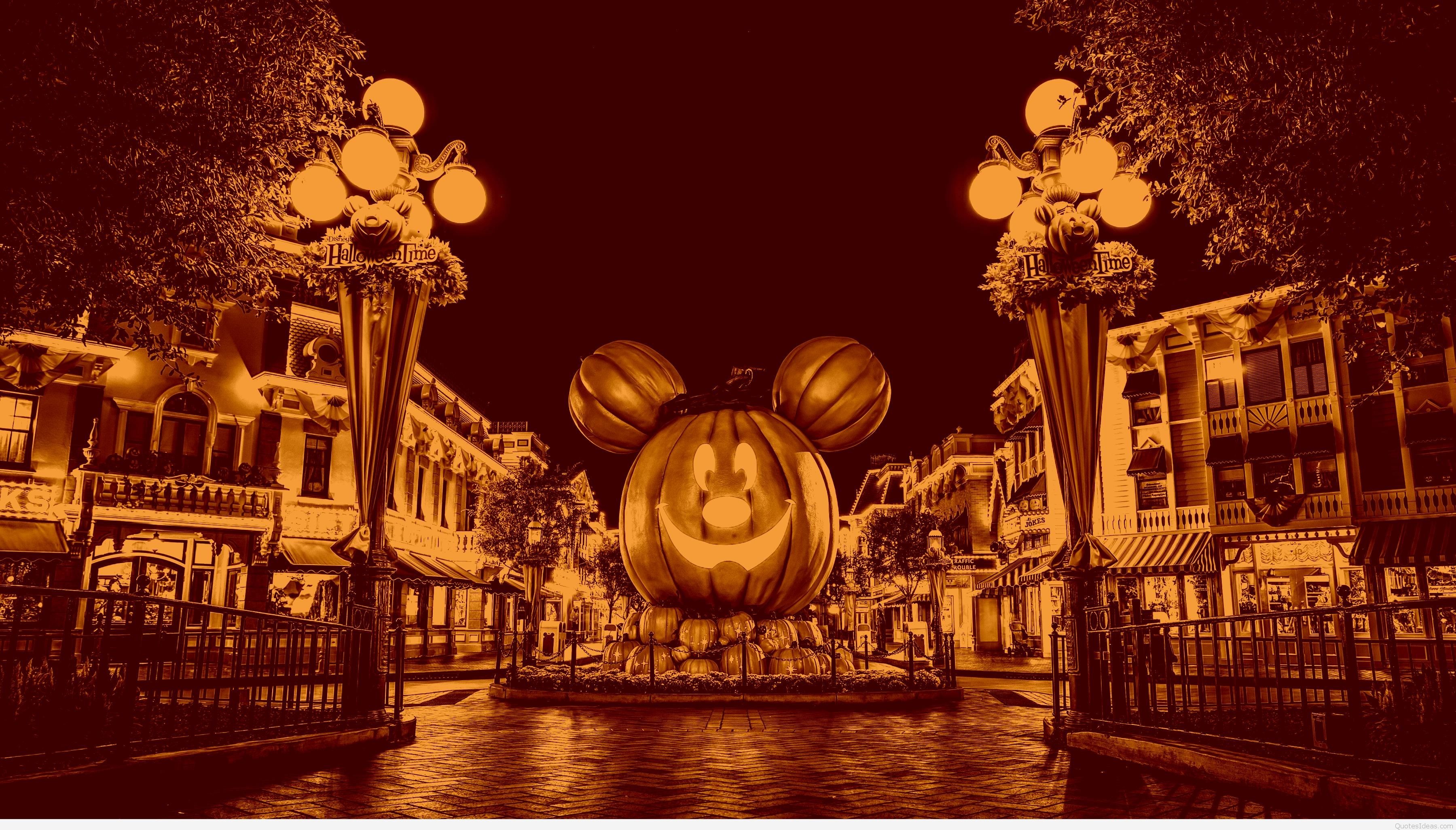 A giant Mickey Mouse pumpkin illuminated at night in a sepia-toned Halloween display at Disneyland