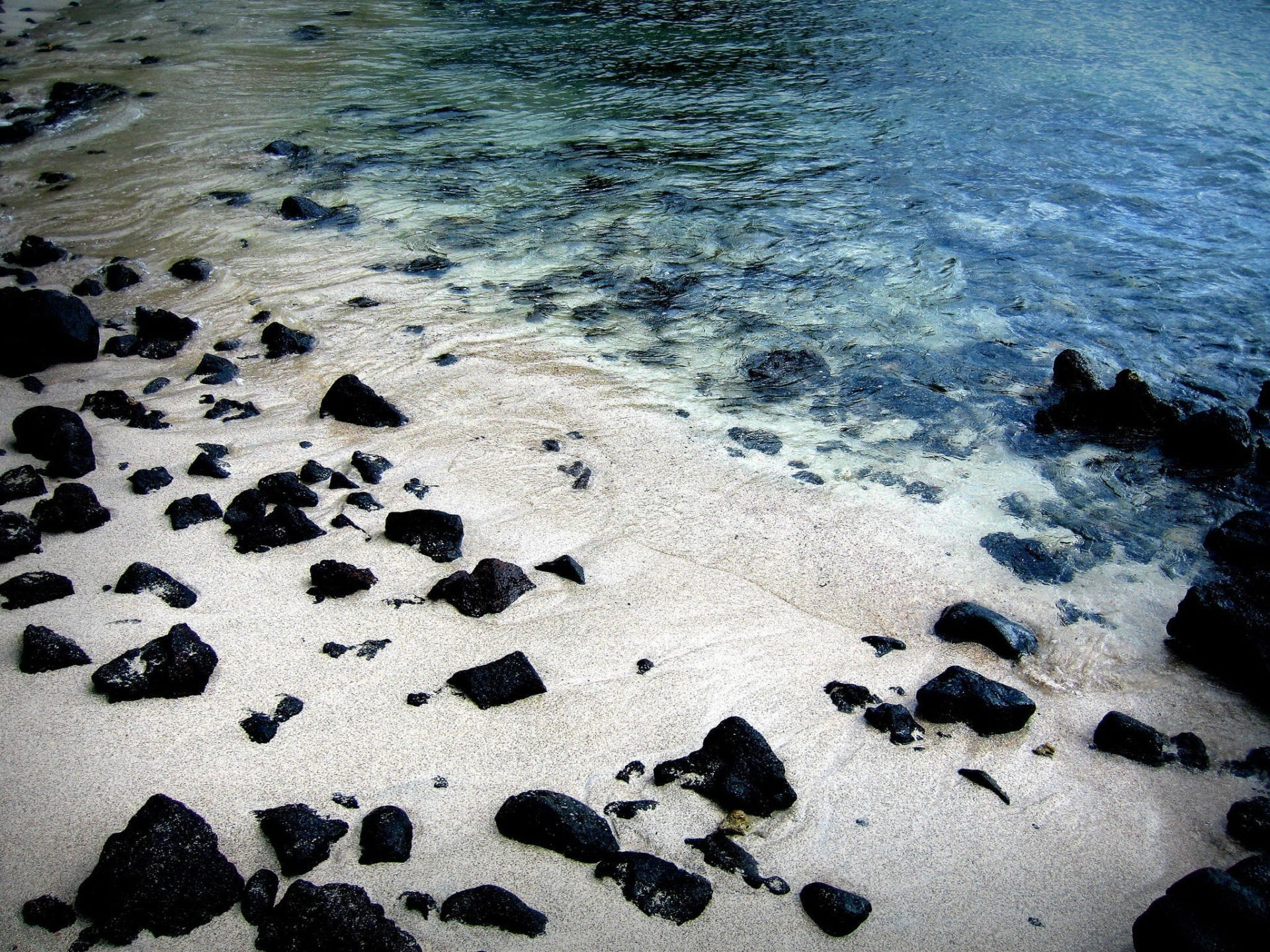 Black Rocks On White Sand Beach Wallpaper