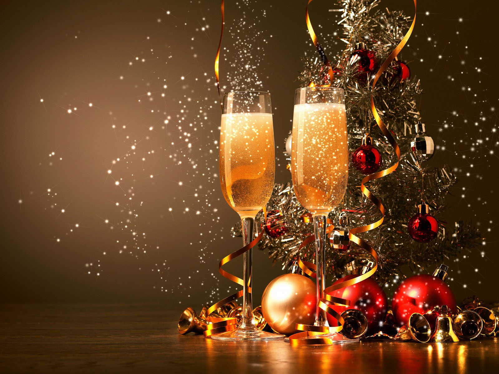 Two champagne flutes filled with bubbly, a decorated Christmas tree, and festive ornaments create a celebratory New Year's scene