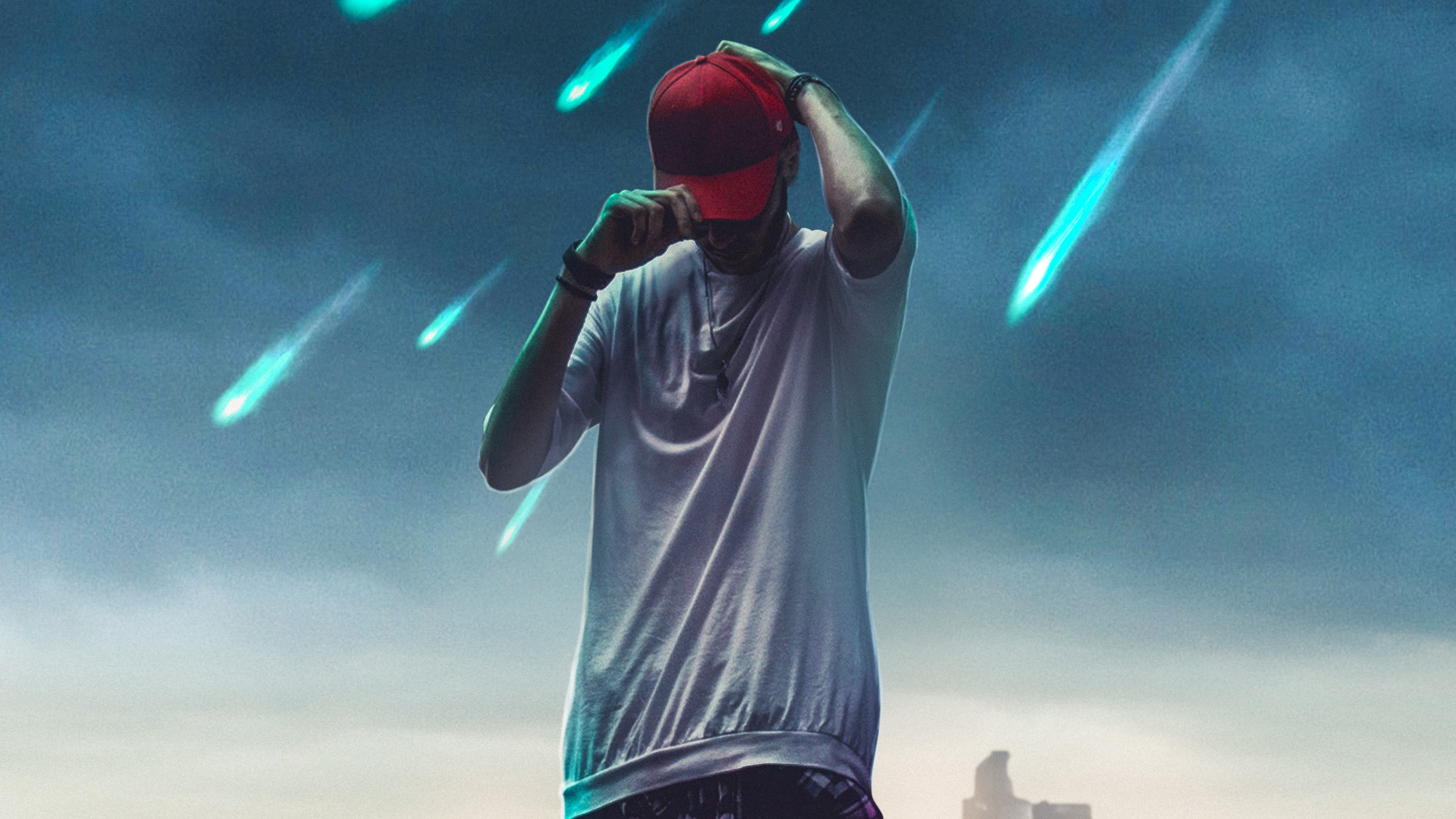 A young man wearing a red baseball cap and a white t-shirt stands against a backdrop of a meteor shower