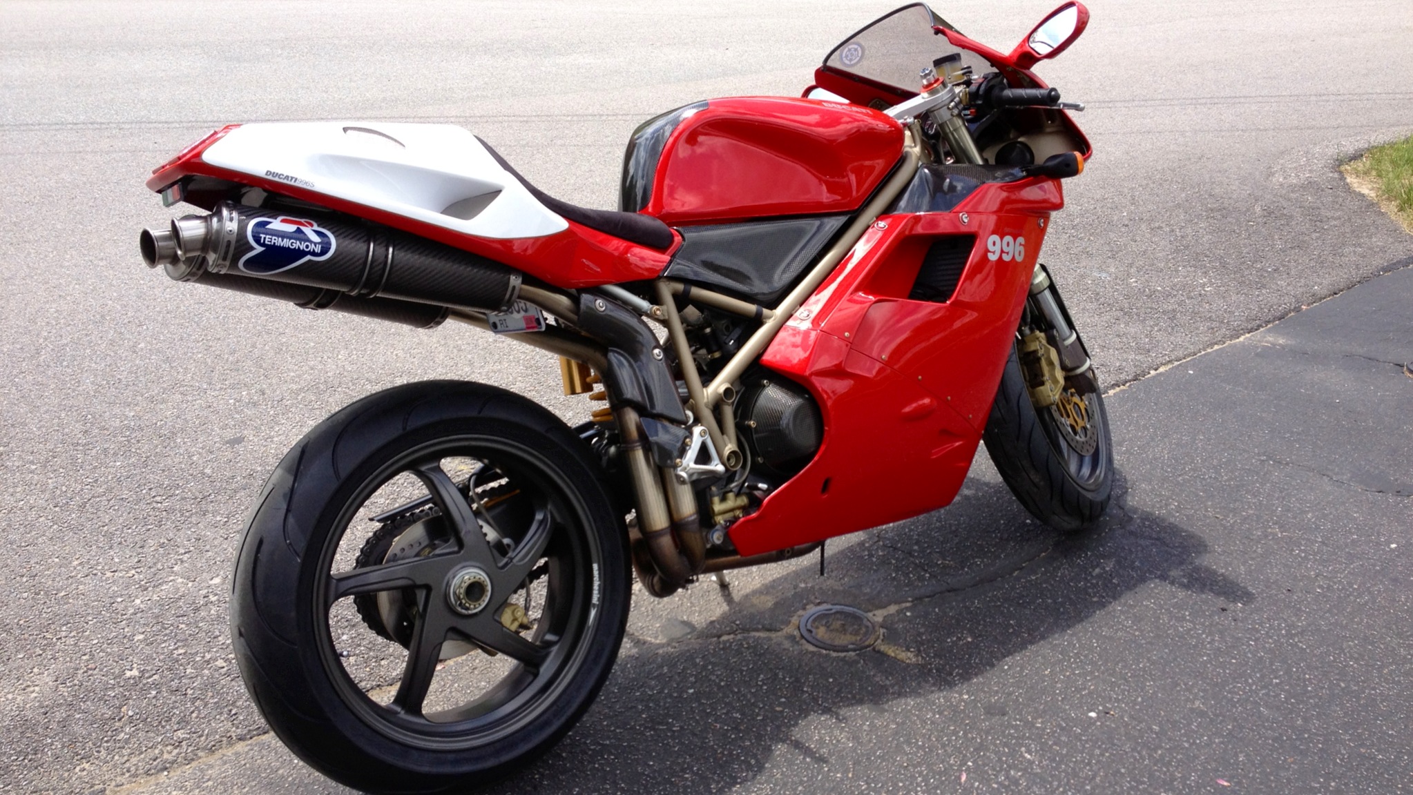 Red and white Ducati 996 motorcycle parked on asphalt