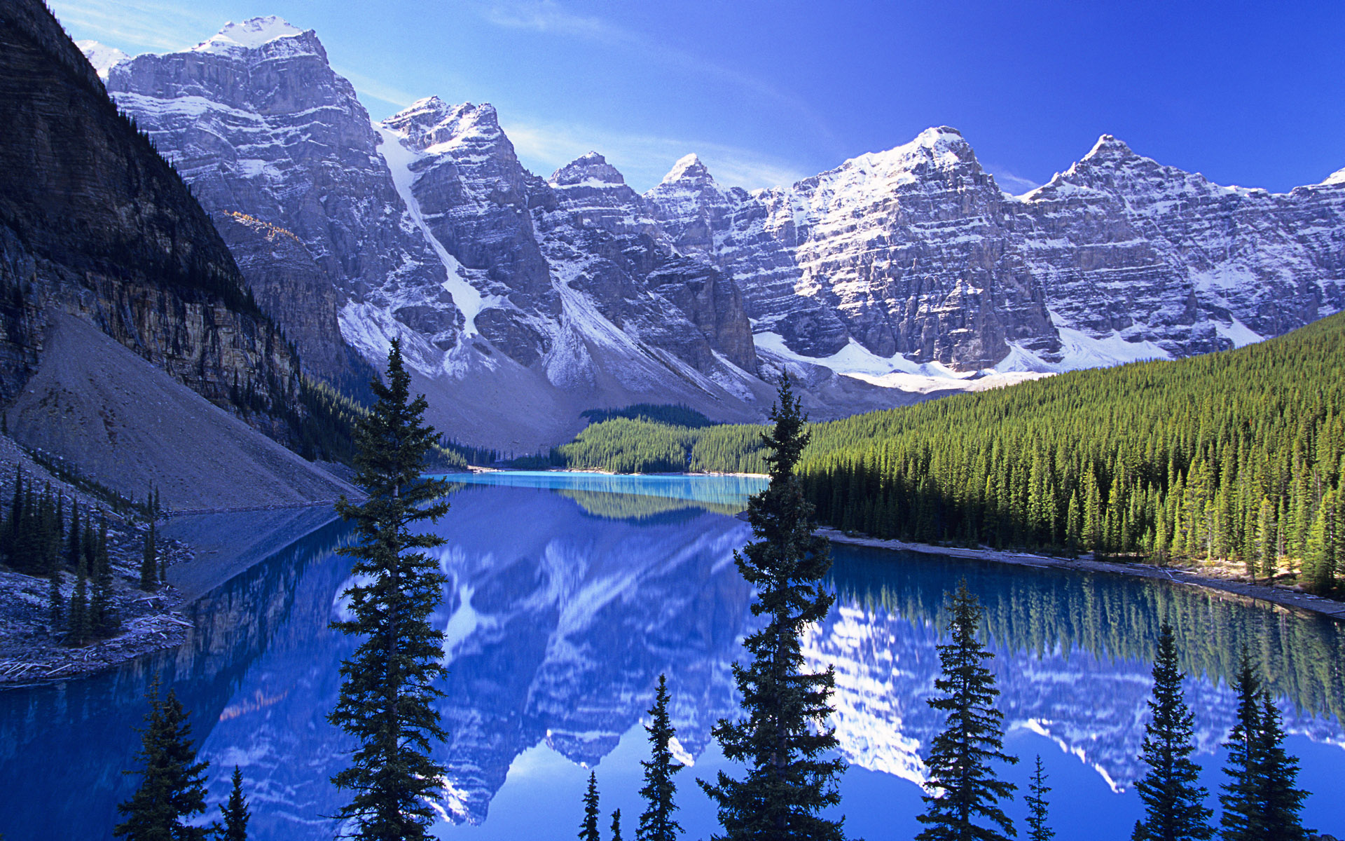 Stunning desktop wallpaper showcasing Moraine Lake in Banff National Park with its turquoise blue water reflecting the surrounding snow-capped mountains and lush green forest