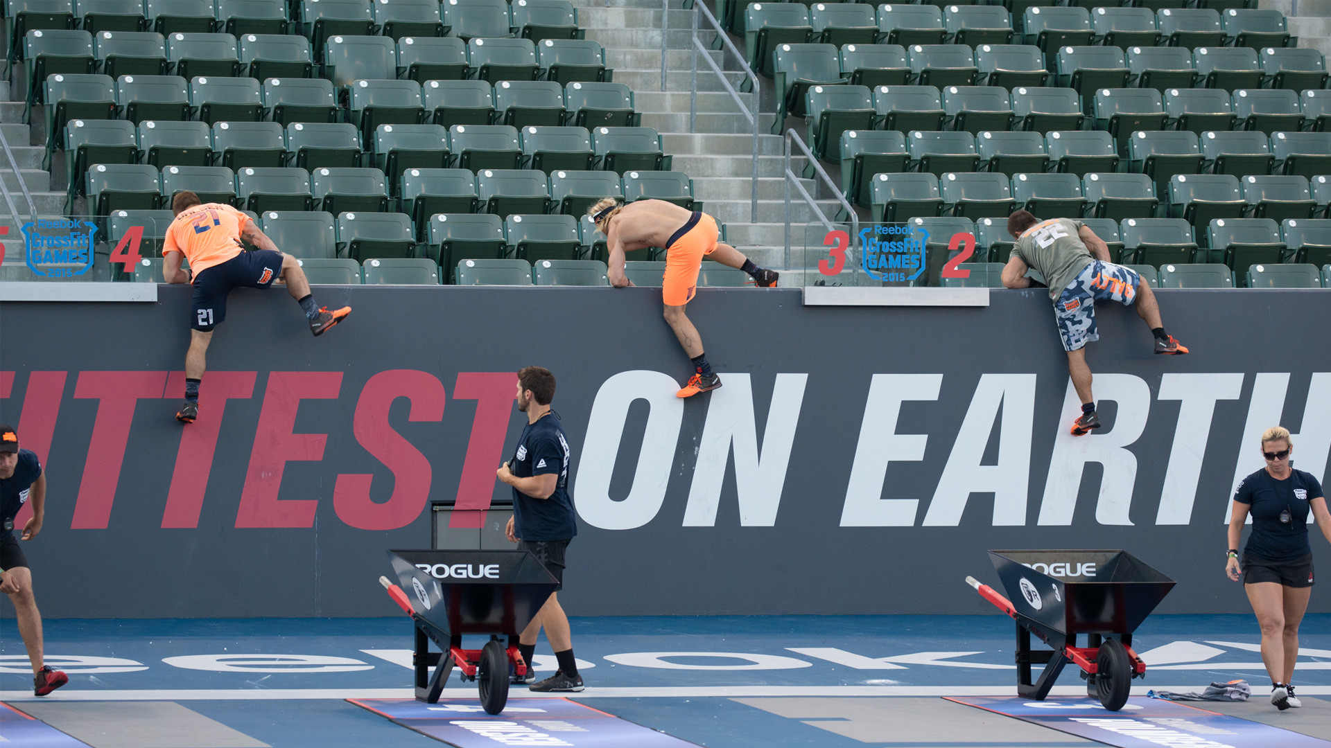 CrossFit athletes scaling a wall during a competition