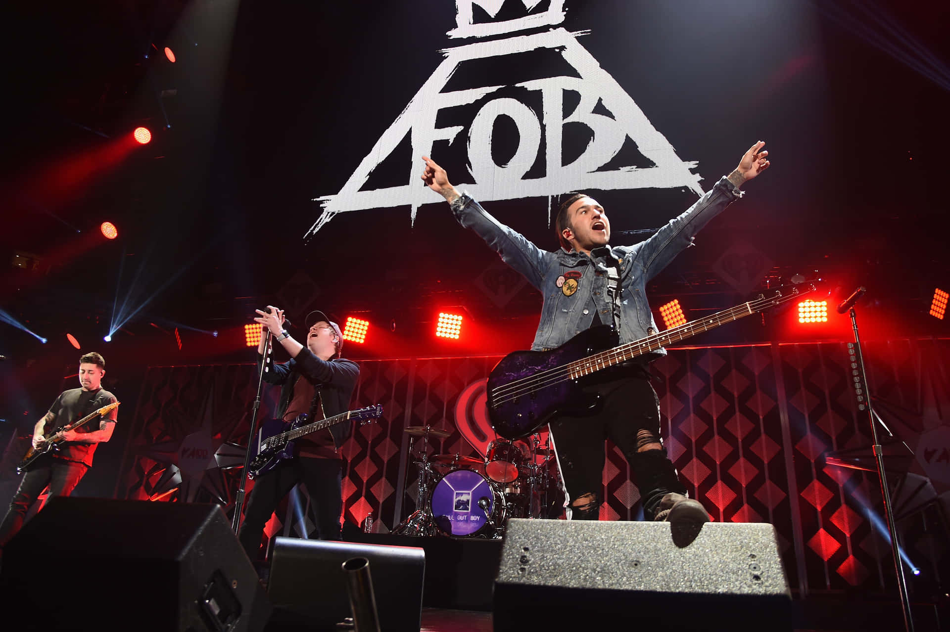 Fall Out Boy performing live on stage, with Pete Wentz playing bass