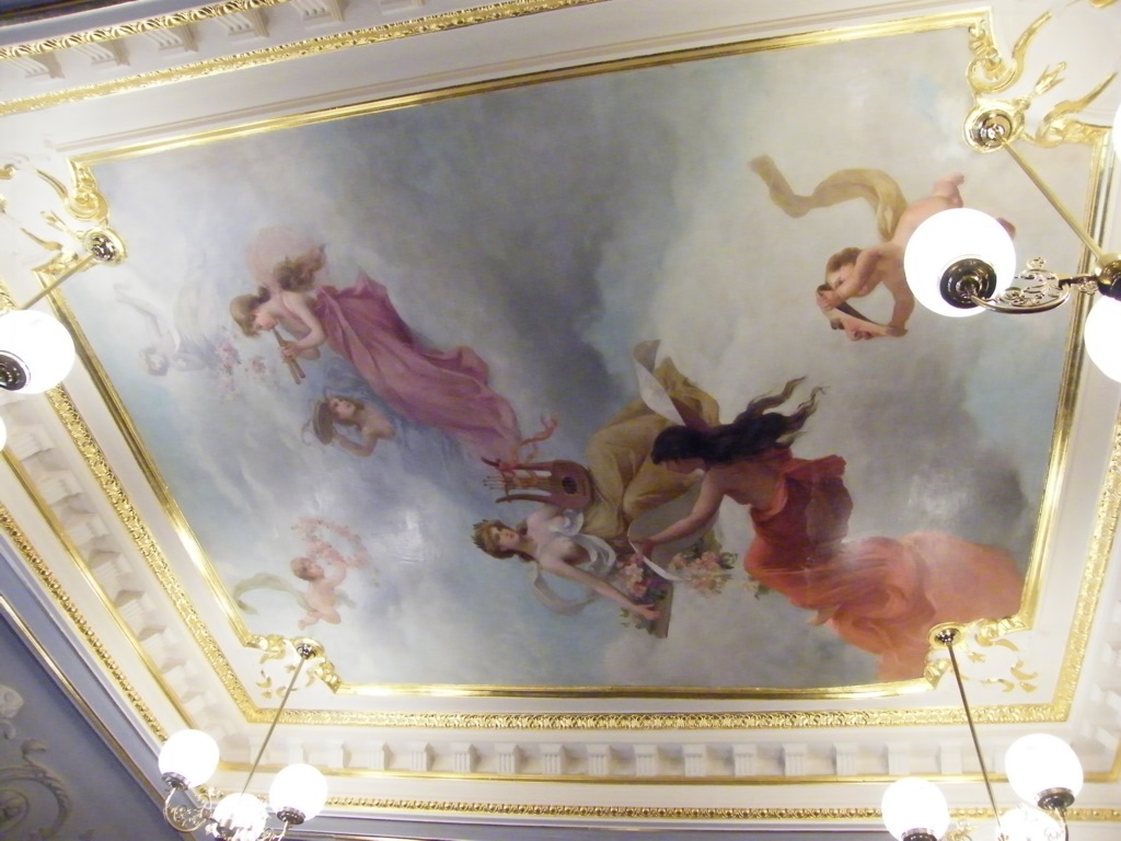 This Close Up Of The Ceiling Mural Shows Cherub With A Mask
