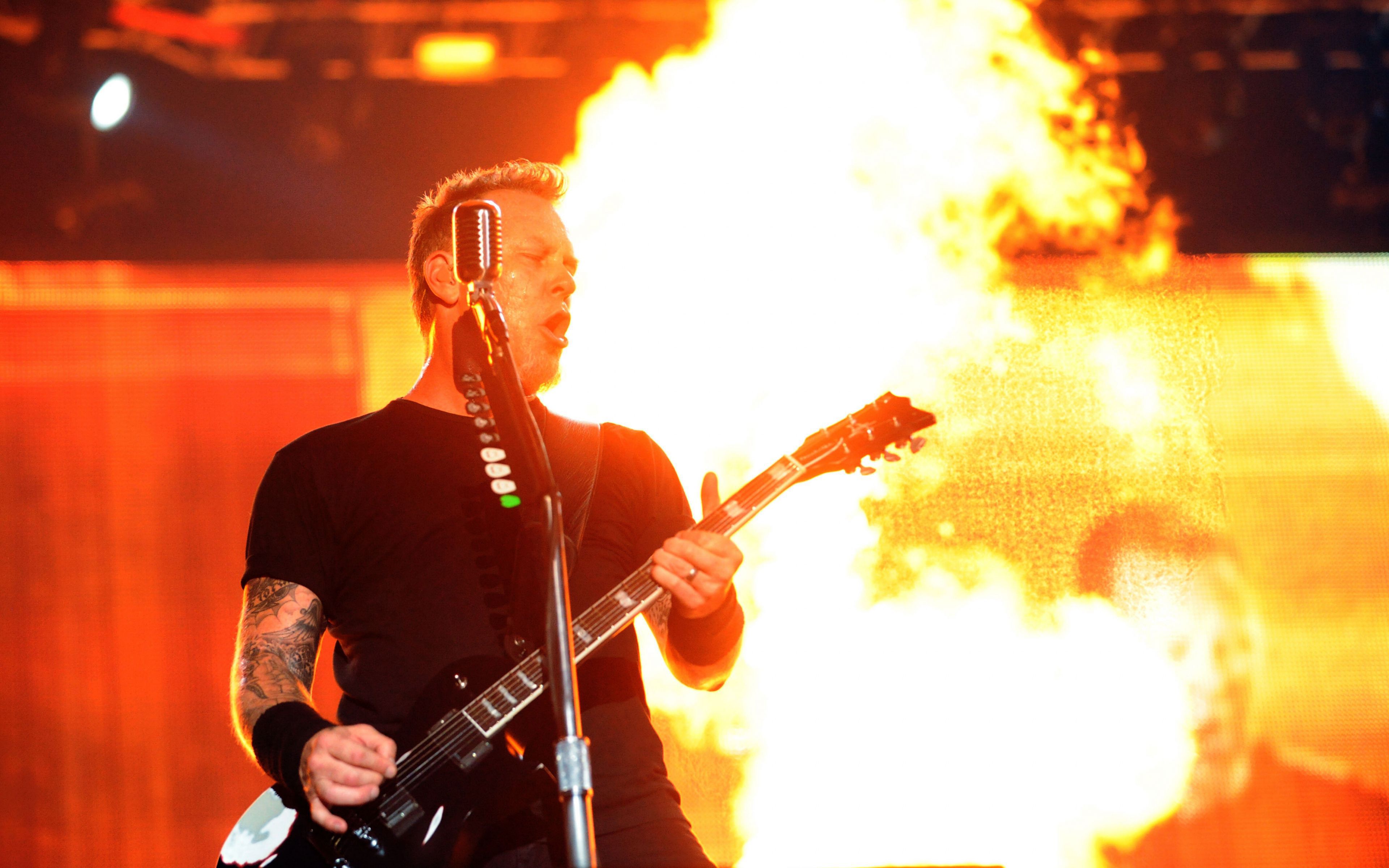 James Hetfield of Metallica performing live on stage with flames in the background