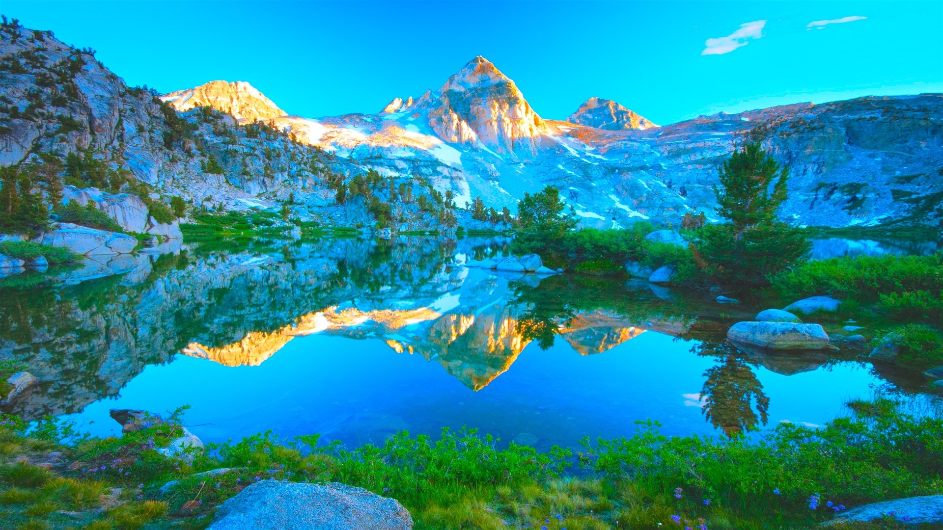 Stunning HD nature wallpaper of a crystal-clear alpine lake reflecting a majestic mountain peak at sunrise