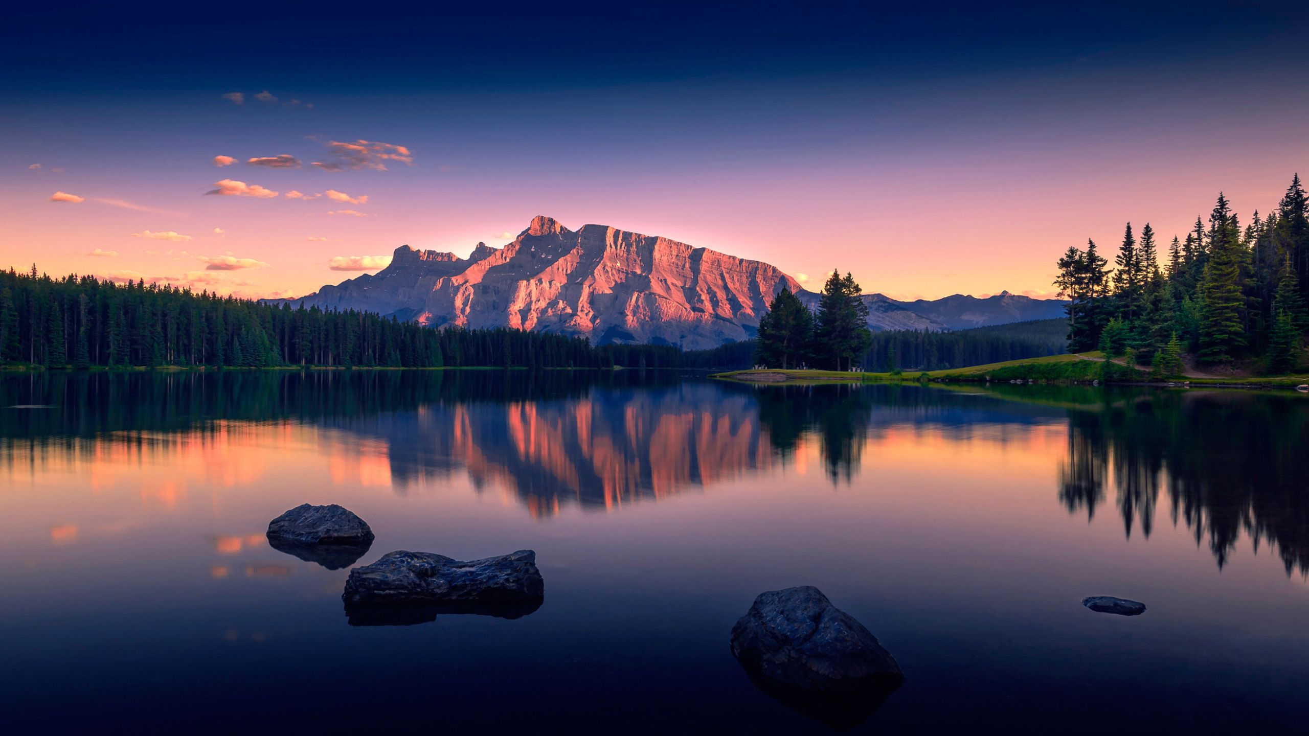 A breathtaking sunset landscape reflecting in a still lake, with a majestic mountain and lush forest in the backdrop