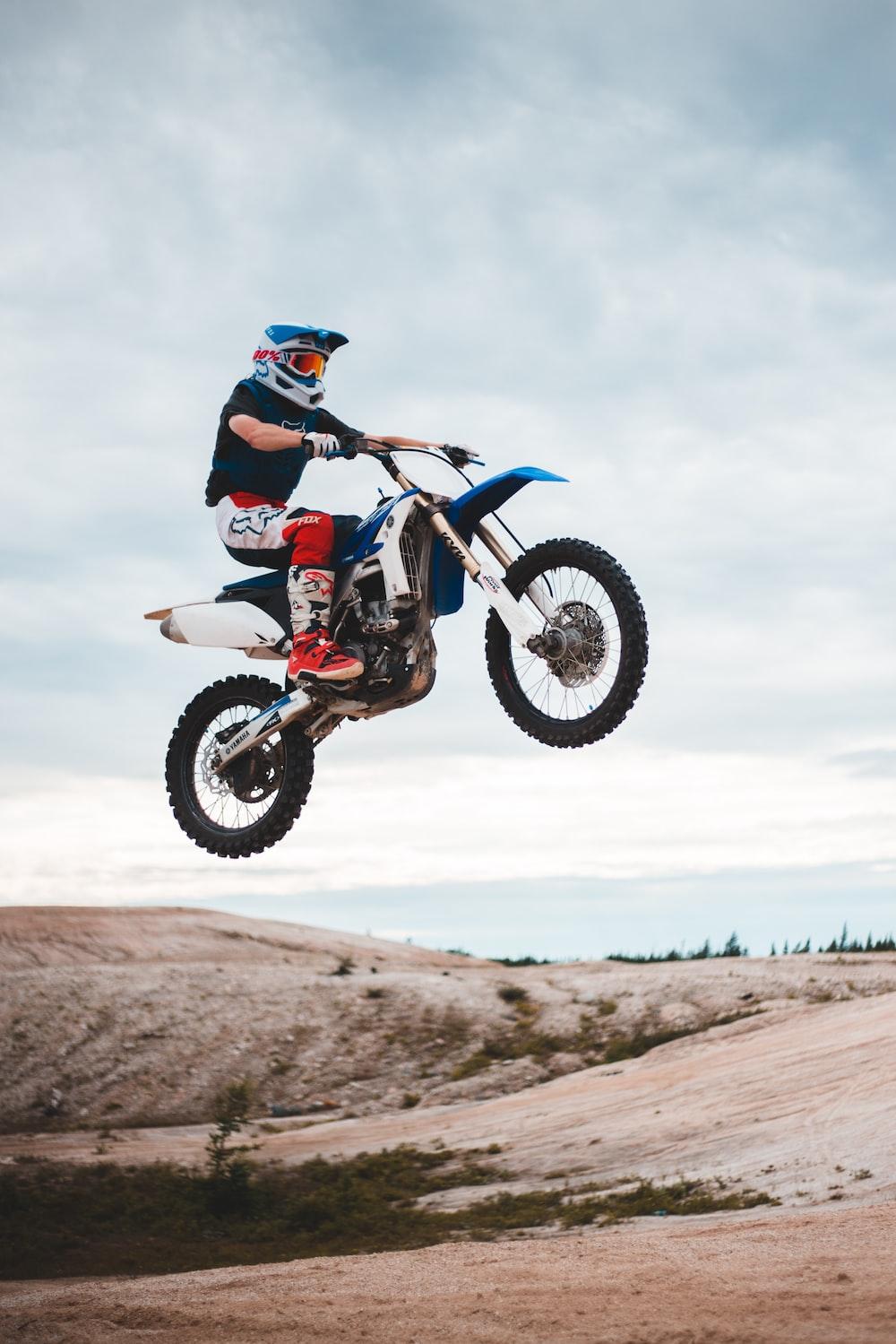 Man Riding Blue And White Motocross Dirt Bike Photo Vehicle
