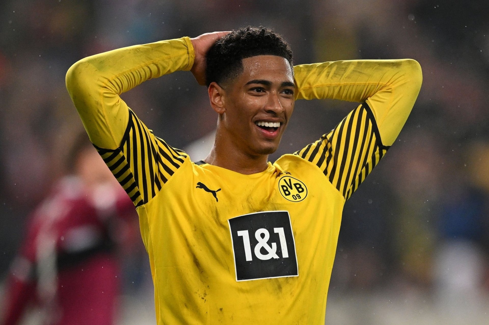 Jude Bellingham smiling in his Borussia Dortmund kit during a football match