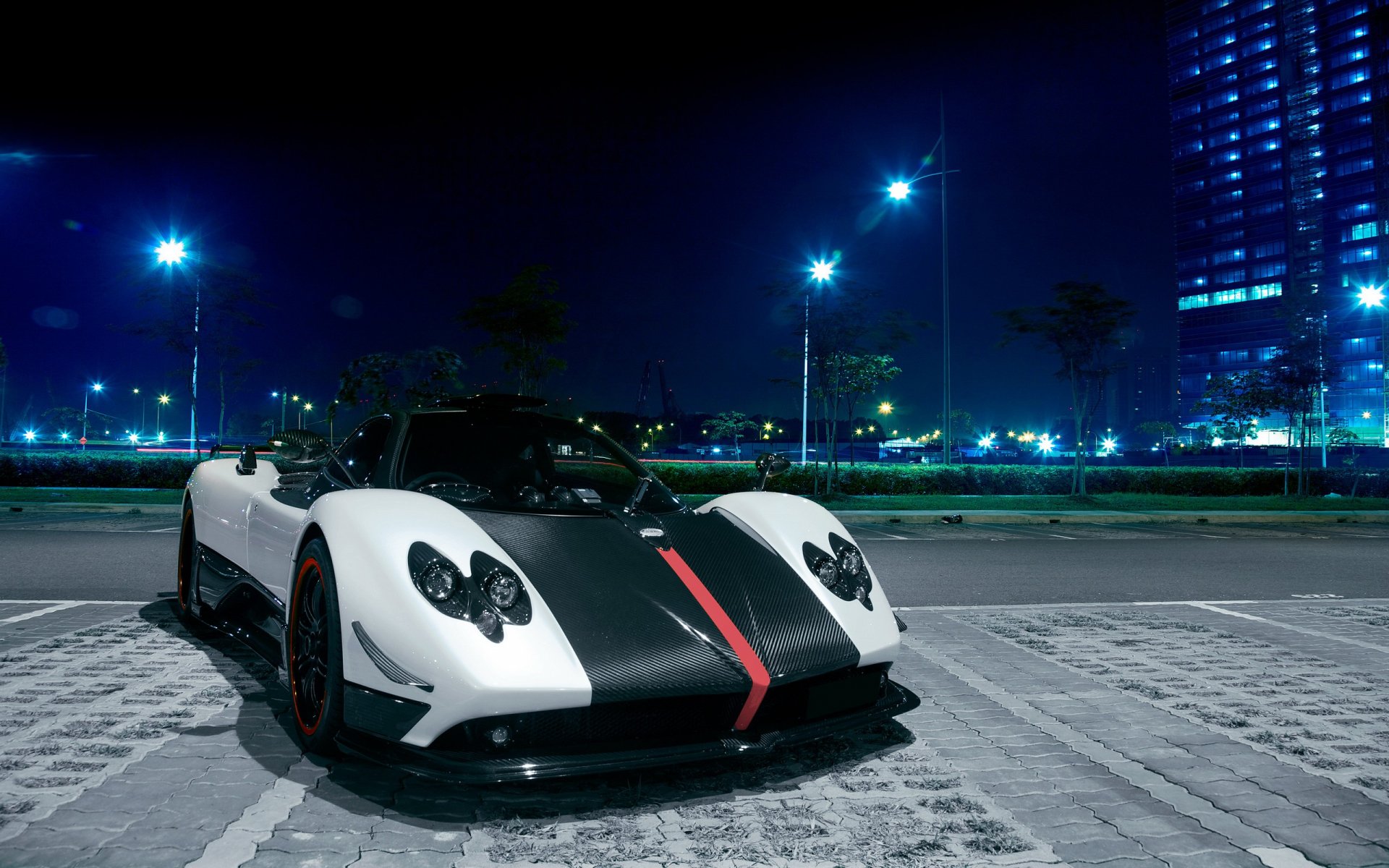 A white and black Pagani Huayra parked in a city at night
