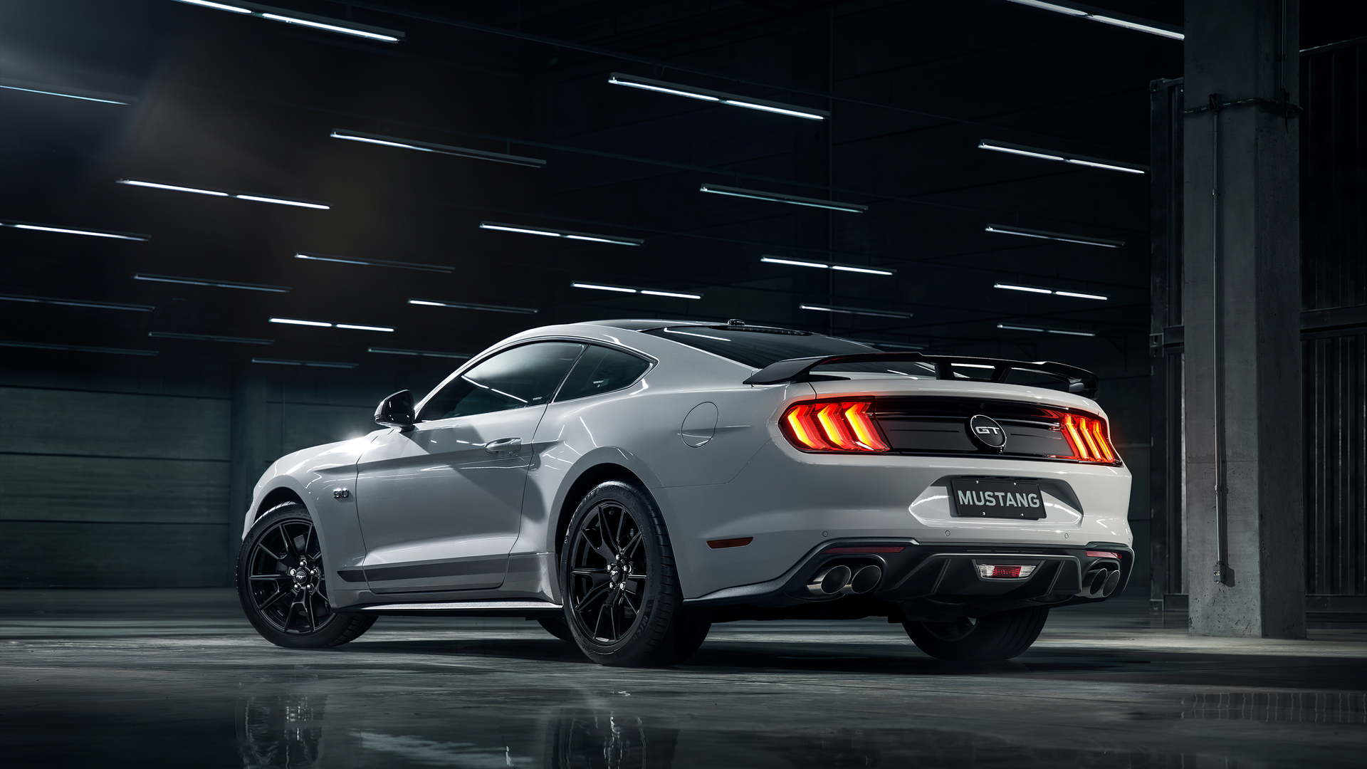 White Ford Mustang GT parked in a dimly lit garage