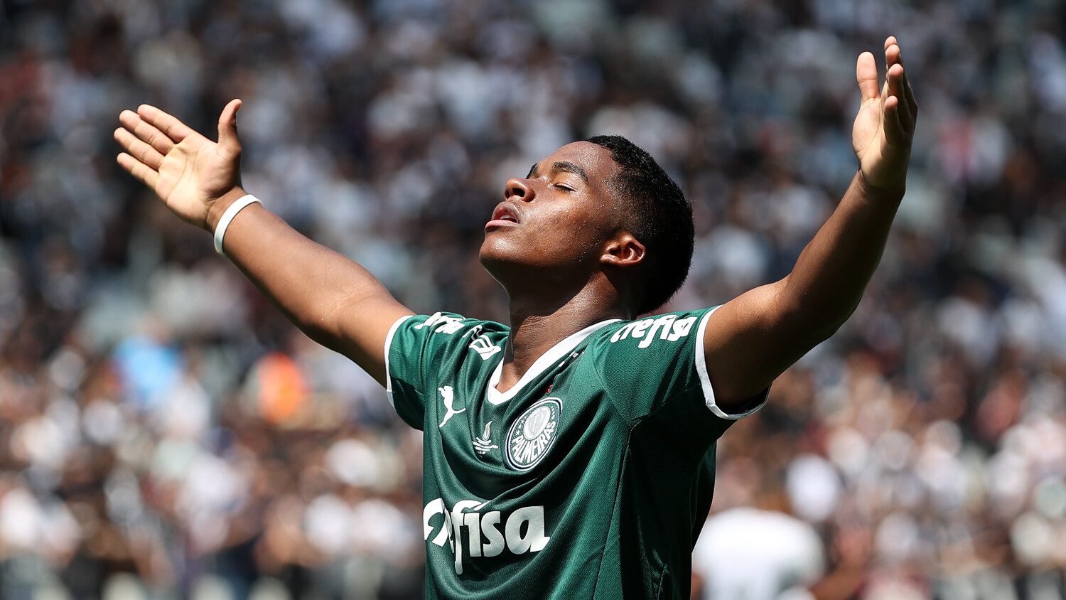 Endrick Felipe celebrating a goal or victory with arms raised and eyes closed